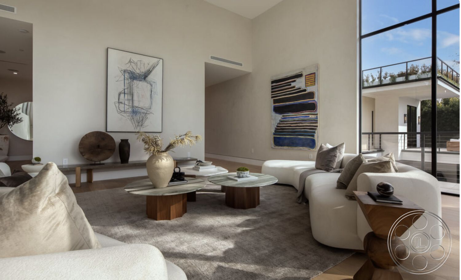 Modern 514 - neutral color palette, round coffee table, built-in shelving, geometric decor elements, urban residential setting, decorative ceramic vase, contemporary light fixtures, low-profile furniture, modern minimalist design, interior area rug, interior hardwood flooring, interior textured plaster walls, interior plant decor, natural light-filled living space, open floor plan living area, exposed ceiling details, exterior glass windows, wall-mounted art display, white upholstered sectional sofa, artwork with abstract shapes