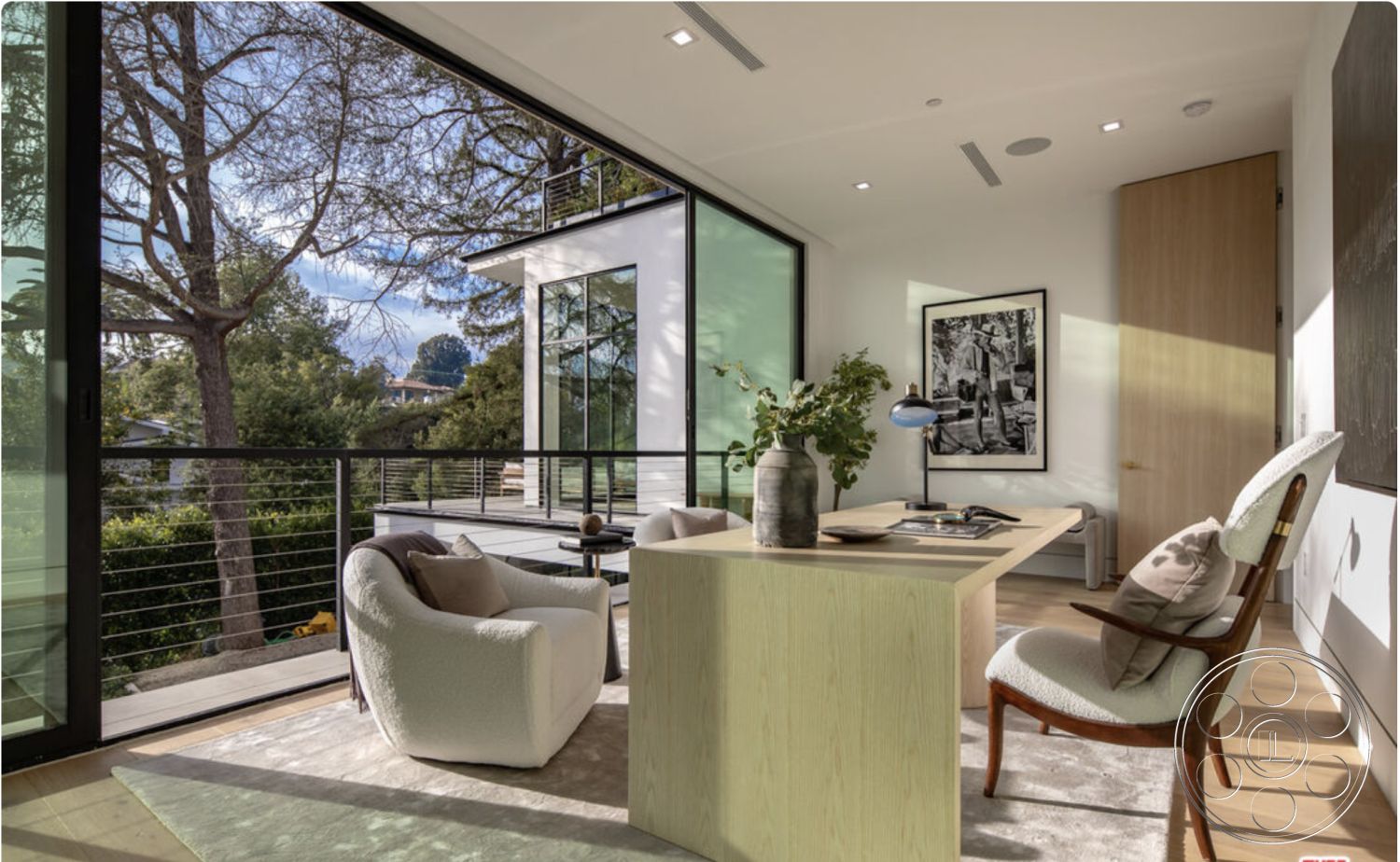 Modern 514 - neutral color palette, large glass sliding doors, light hardwood flooring, decorative indoor plant, upholstered armchair, minimalist decor elements, open and airy layout, natural light from floor-to-ceiling windows, flush-mount ceiling lights, interior modern workspace, contemporary wall art, textured white walls, wood desk with minimalist design, exterior tree view, steel railing balcony