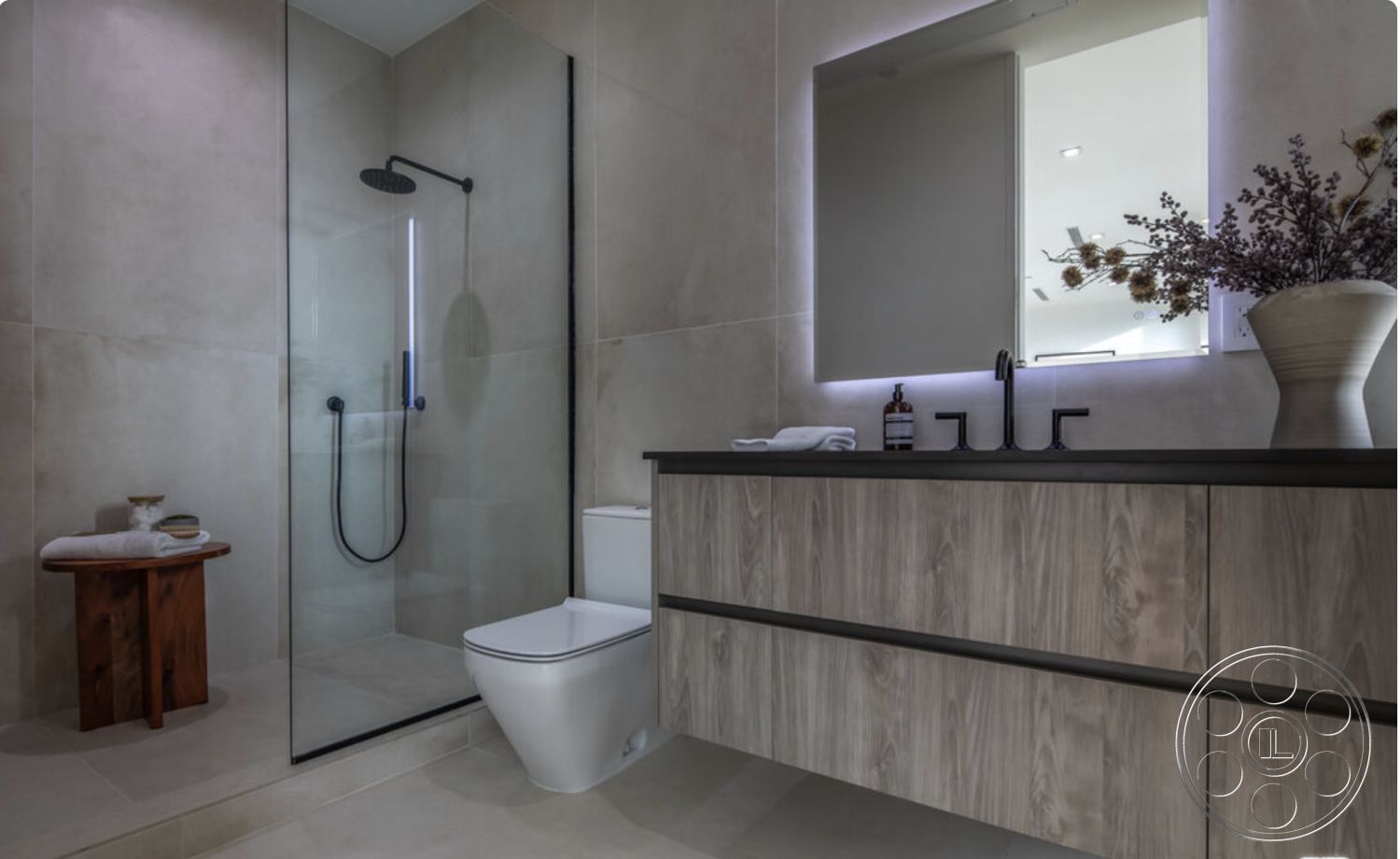 Modern 514 - neutral color palette, backlit mirror, minimalistic design elements, modern faucet fixtures, wood accent side table, interior bathroom with tile shower walls, exposed glass shower doors, floating vanity with dark wood finish, earth-toned tile flooring, linear shower head, bathroom with contemporary lighting