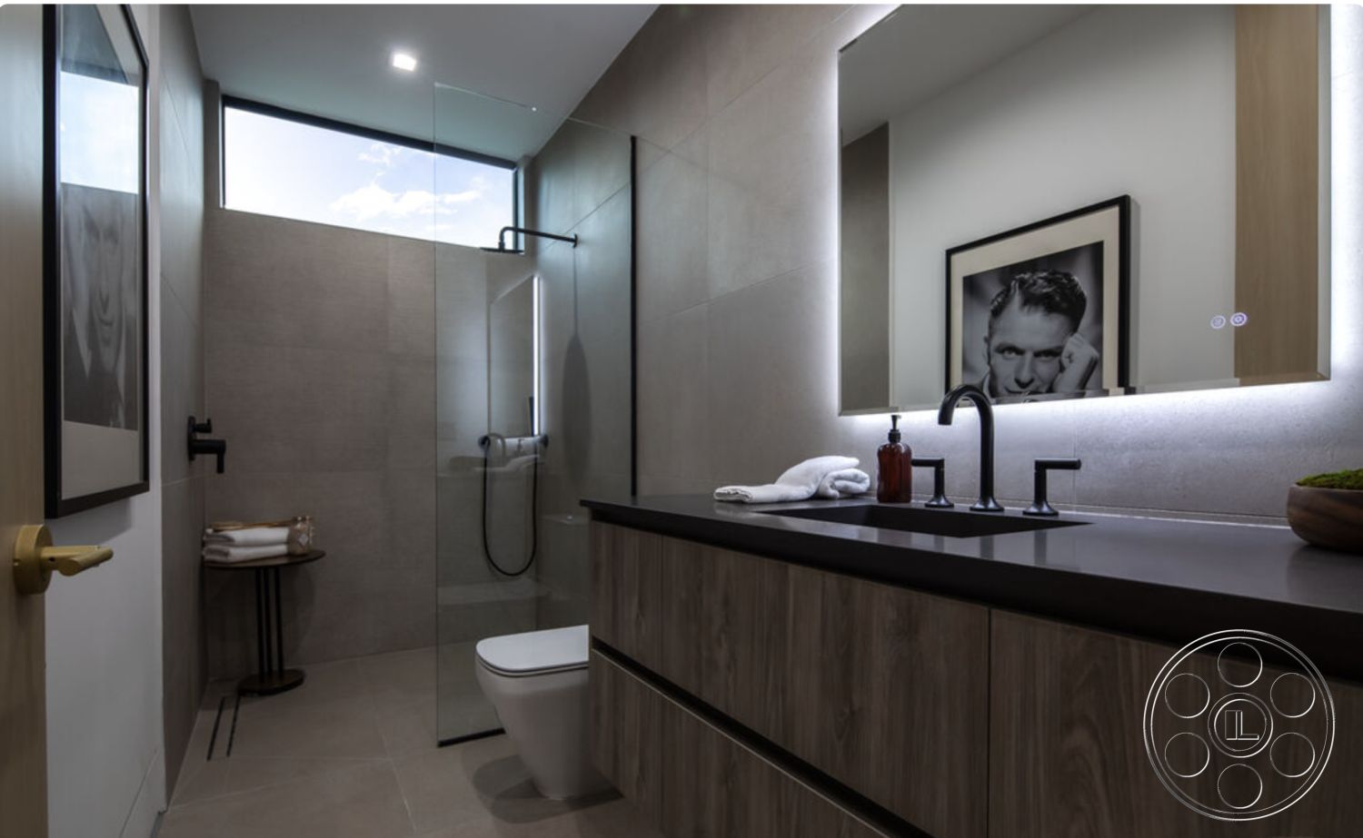 Modern 514 - minimalist decor, contemporary style, recessed lighting, glass shower enclosure, white towels, textured plaster walls, black quartz countertop, round wooden side table, interior bathroom, large format tile shower walls, wall-mounted black faucet, wood veneer bathroom cabinets, floating vanity design, modern bathroom mirror with LED backlight, framed black and white art