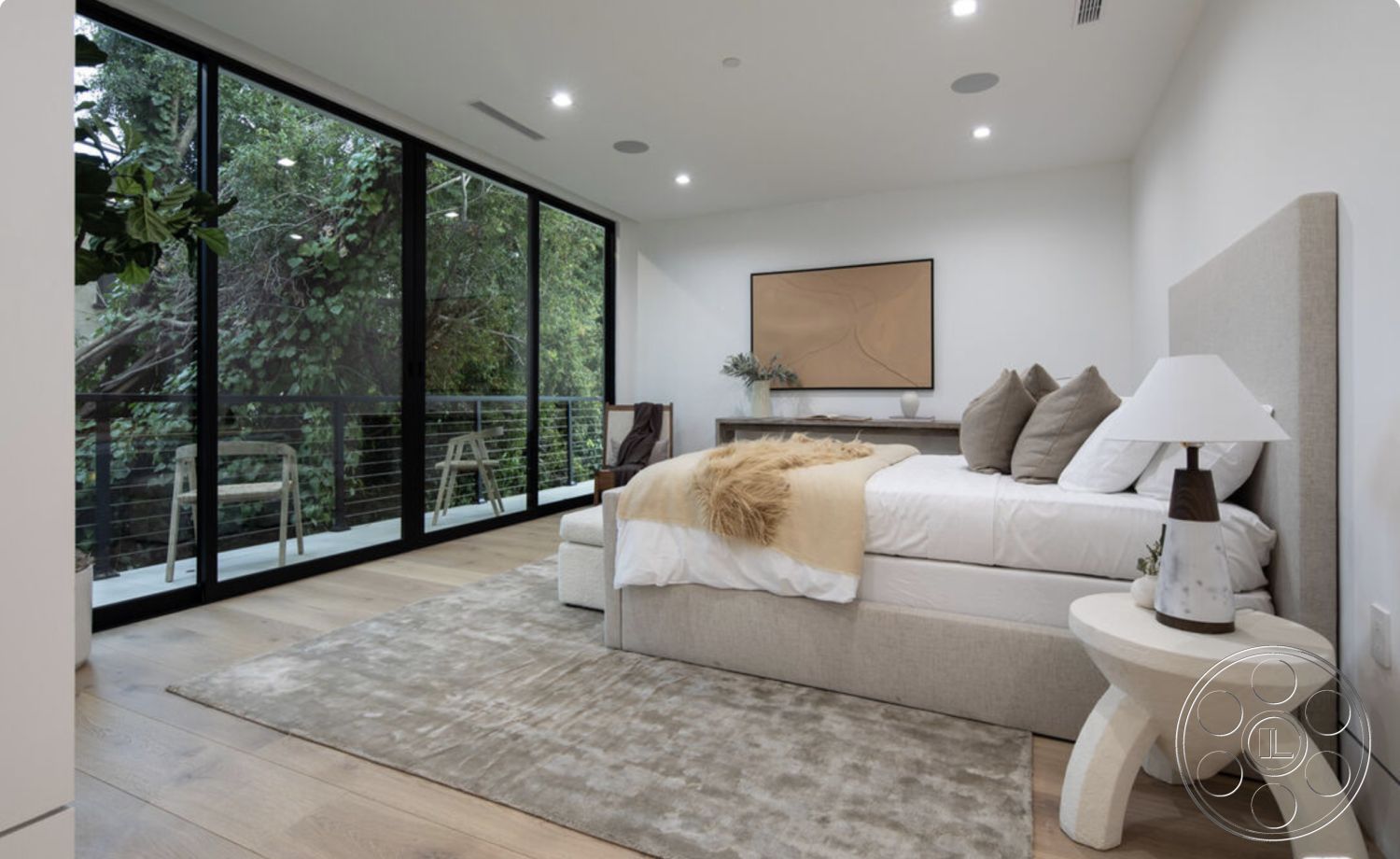 Modern 514 - bright natural light, decorative wall art, plush area rug, smooth white walls, hardwood bedroom floors, minimalist bedside table, large glass patio doors, modern lamp design, spacious master bedroom, neutral beige bed frame, greenery from surrounding trees, exposed black metal railing