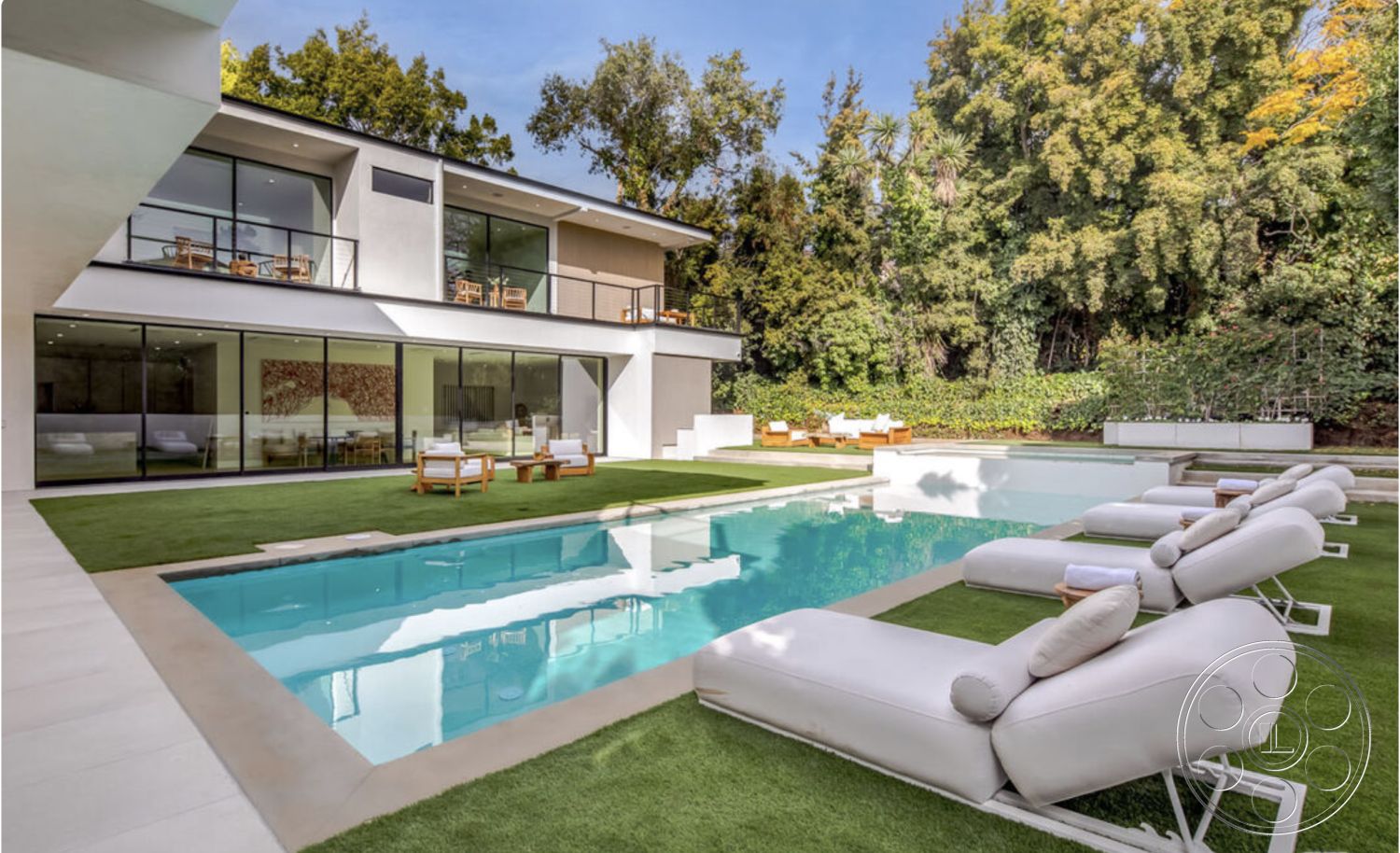 Modern 514 - glass sliding doors, floor-to-ceiling windows, open concept living space, rectangle swimming pool, minimalist architectural details, urban hillside setting, white stucco exterior walls, contemporary residential design, synthetic grass lawn, poured concrete patio floor, modern lounge chairs with white upholstery, wood deck area with outdoor seating, exposed concrete pool border, terraced landscaping with greenery, interior and exterior flow