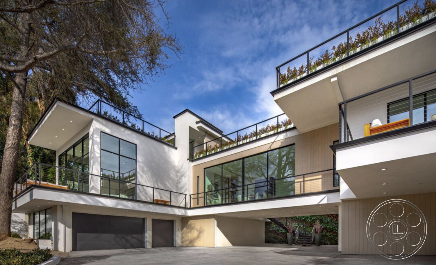 Modern 514 - curved driveway, surrounded by greenery, modern two-story home, contemporary architectural style, urban hillside location, exterior concrete driveway, exterior stucco walls, exterior wooden deck, floor-to-ceiling glass doors, exterior glass windows, exterior flat roof, exterior wood siding, exterior metal railings, exterior balcony with planters, horizontal wood beam detailing, vaulted exterior ceiling, open-air outdoor living space