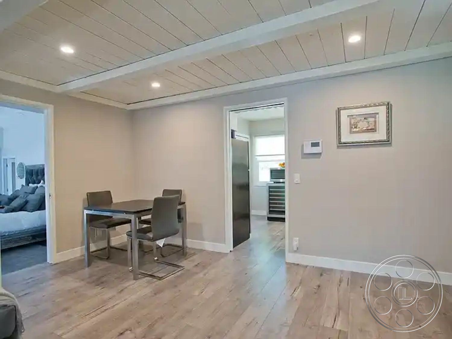 Americana 430 - neutral color palette, open floor plan, recessed ceiling lights, light-filled space, modern dining chairs, exposed wood ceiling beams, interior hardwood living room floors, minimalist interior design, gray painted walls, frame artwork on wall, rectangle dining table, seamless kitchen transition, bright kitchen access, stylish contemporary aesthetics