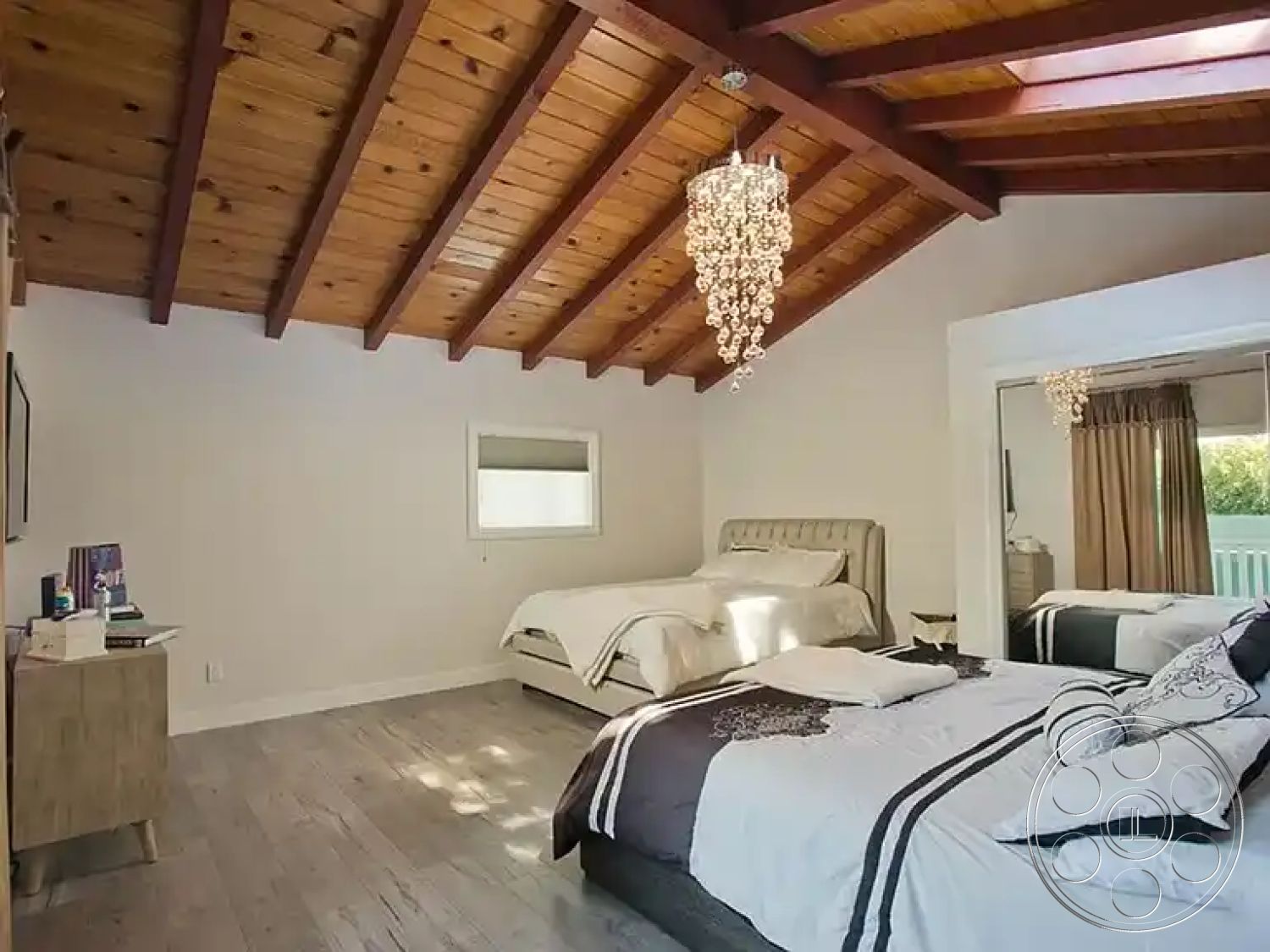 Americana 430 - textured plaster walls, mirrored closet doors, light-colored bedding, exposed wood ceiling beams, interior bedroom design, hardwood bedroom floors, white painted walls, crystal chandelier lighting, vaulted bedroom ceiling, modern room decor