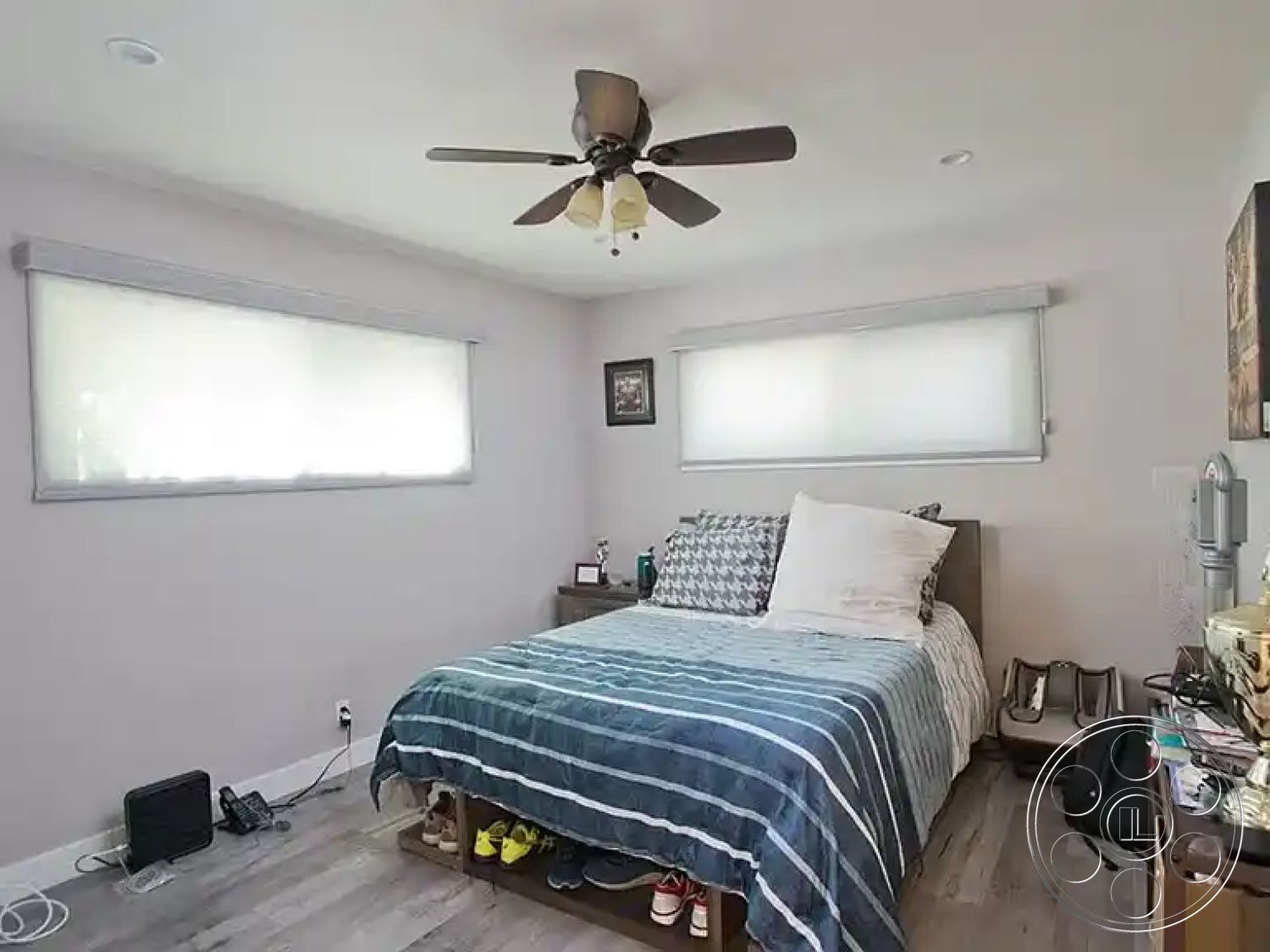 Americana 430 - wood nightstand, interior bedroom, hardwood bedroom floors, light gray painted walls, queen-sized bed with striped duvet, modern ceiling fan with light fixtures, roller blinds on windows, decorative wall art frame, minimalist room decor