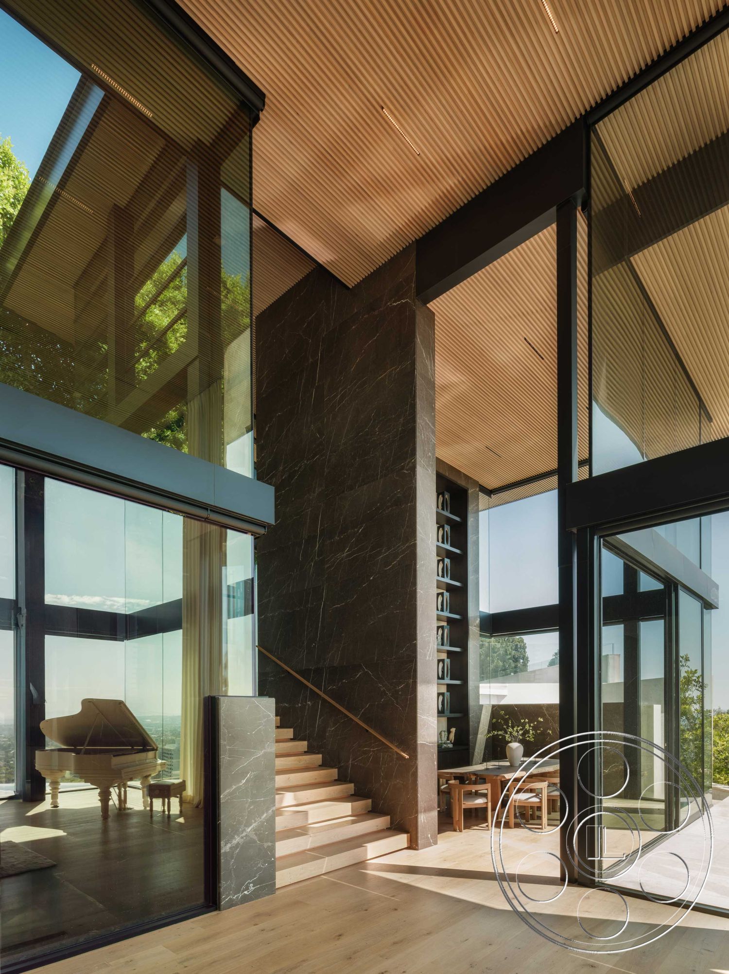 Modern 515 - wooden dining table, contemporary dining area, natural light-filled space, white painted walls, floor-to-ceiling glass windows, minimalist architectural design, polished hardwood flooring, exposed structural beams, light wood ceiling panels, contemporary interior styling, interior living room with glass walls, dark marble accent wall, open staircase with wood treads, modern piano corner, urban hillside home setting, multi-level open floor plan, elegant glass partition, sweeping city views, streamlined design elements, glass door access to outdoor space