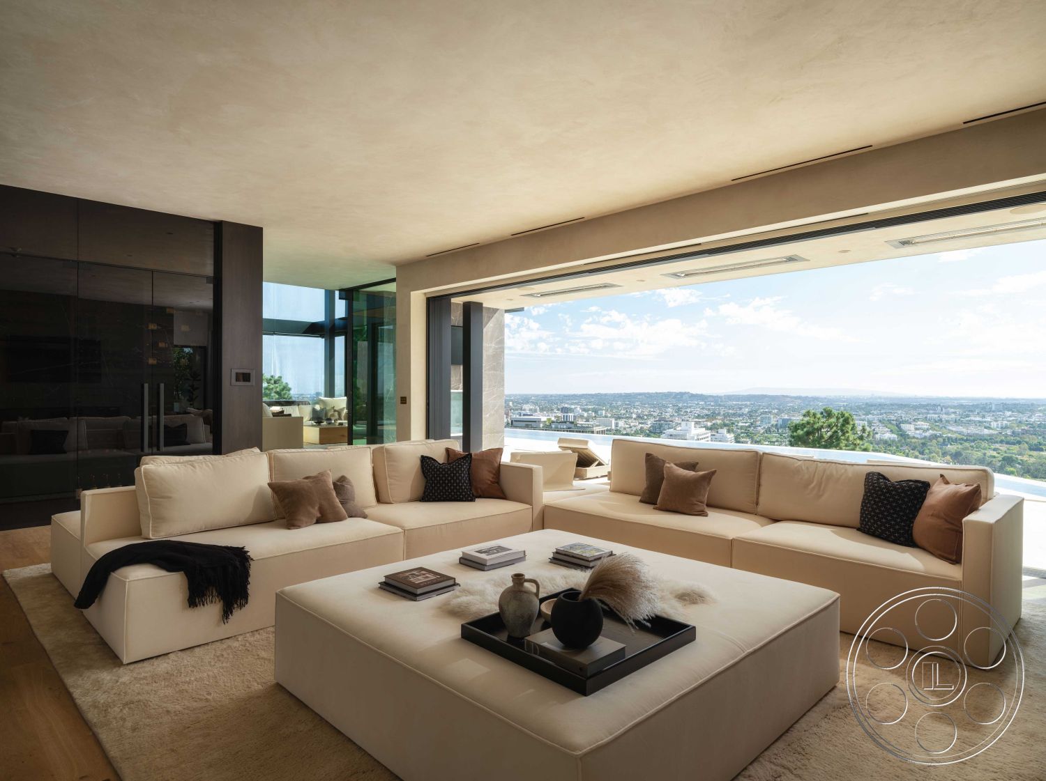 Modern 515 - neutral color palette, textured area rug, light hardwood flooring, open concept layout, modern coffee table, city skyline view, indoor greenery, contemporary aesthetic, large sectional sofa, ambient lighting fixtures, sliding glass door access, interior living room, minimalist furniture design, floor-to-ceiling glass walls, panoramic window design, elevated hillside location, plaster ceiling finish, sculptural decor accents, luxurious cushions