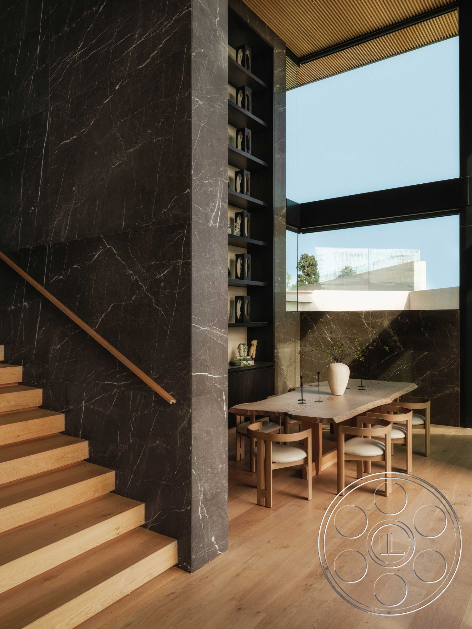 Modern 515 - neutral color palette, floor-to-ceiling windows, contemporary architecture, textured wall paneling, black marble accent wall, elegant dining table, indoor plant decor, natural light interior, open concept living area, interior modern aesthetic, modern furniture design, light hardwood staircase, minimalist dining space, wood beam ceiling detail, exposed wood stair treads, simple metal candle holders, subtle decorative vases, gorgeous outdoor view