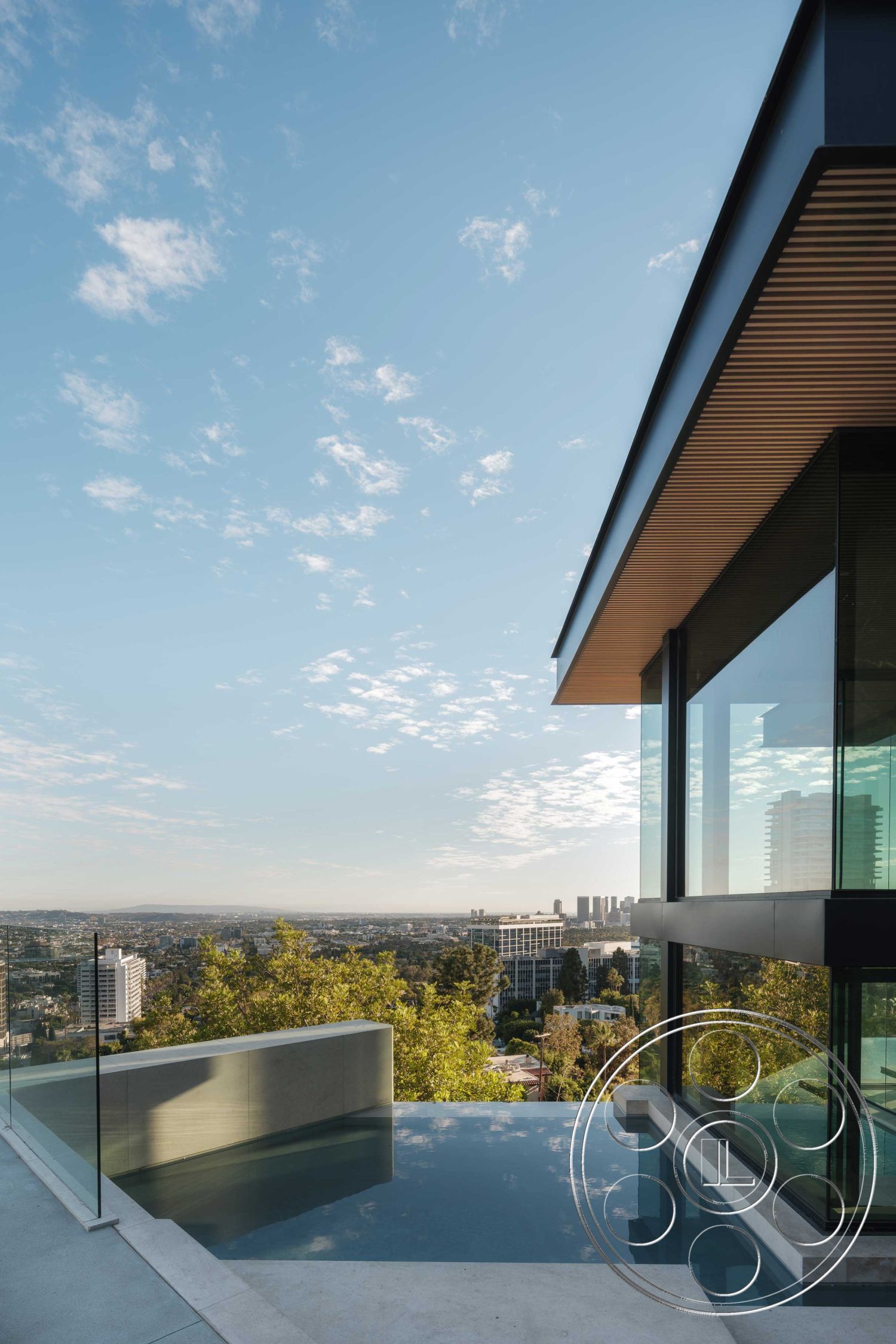 Modern 515 - exterior concrete patio floor, exterior concrete pool border, interior vaulted ceiling, interior contemporary design, interior natural light, interior hardwood flooring, interior open floor plan, exterior infinity pool, setting hillside location, exterior glass walls, interior large sliding glass doors, exterior wooden eaves, exterior minimalist landscaping, interior modern kitchen, setting urban skyline view, setting contemporary residential, setting lush green surroundings, architectural style modern, architectural detail clean lines, architectural detail cantilevered roof