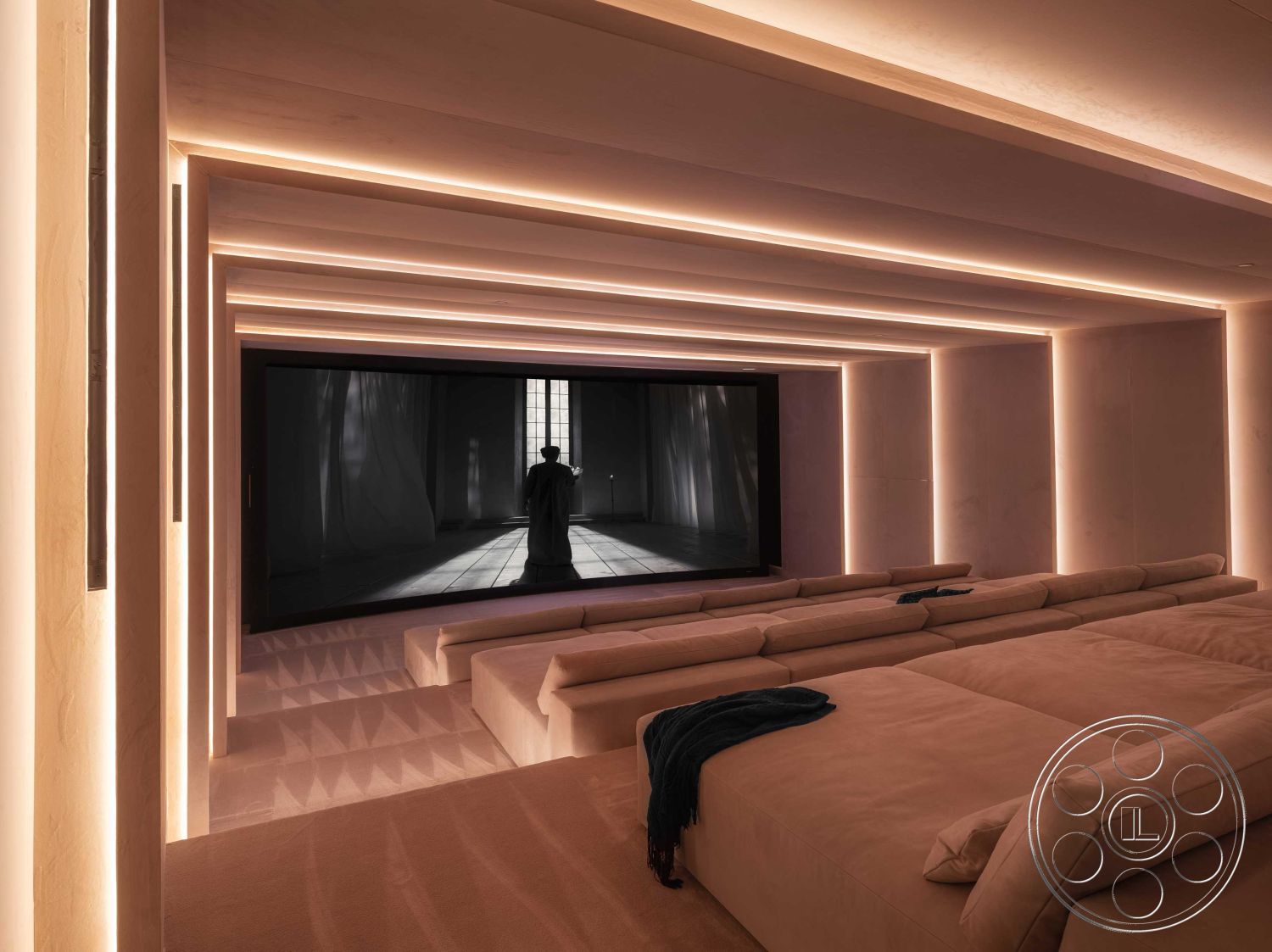 Modern 515 - interior cinema room, sofa seating in soft fabric, recessed lighting with warm glow, minimalist wall design with textured finish, large flat-screen television installation, dim ambient lighting for theater-like atmosphere, integrated lighting in ceiling ledges, luxury soft seating arrangement, architectural ceiling lines with layered design, neutral color palette for a calm environment, hidden audio equipment integration, cozy home theater experience, customized entertainment space, acoustic treatment elements, seamless blend of technology and design