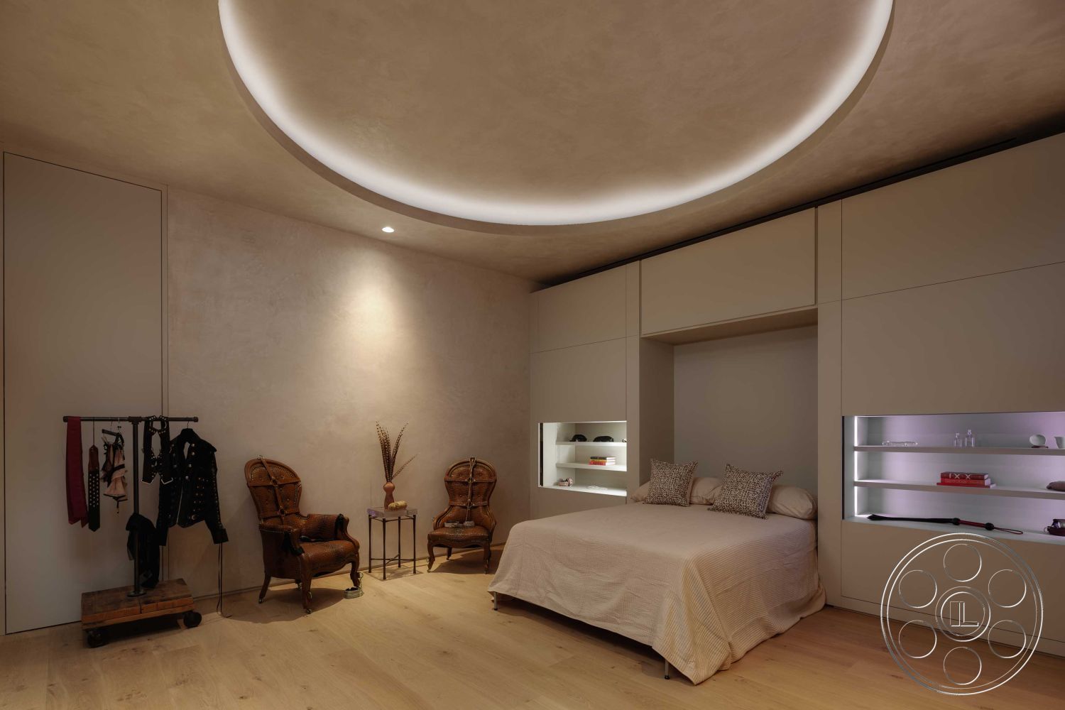 Modern 515 - modern minimalist design aesthetic, interior bedroom with hardwood flooring, smooth plaster walls with warm tone, curved ceiling with recessed lighting, built-in storage cabinetry with minimalist design, decorative accent lighting in shelving, vintage rattan armchairs, neutral color palette with textured bedding, open space layout with natural light, functional dressing area with clothing rack