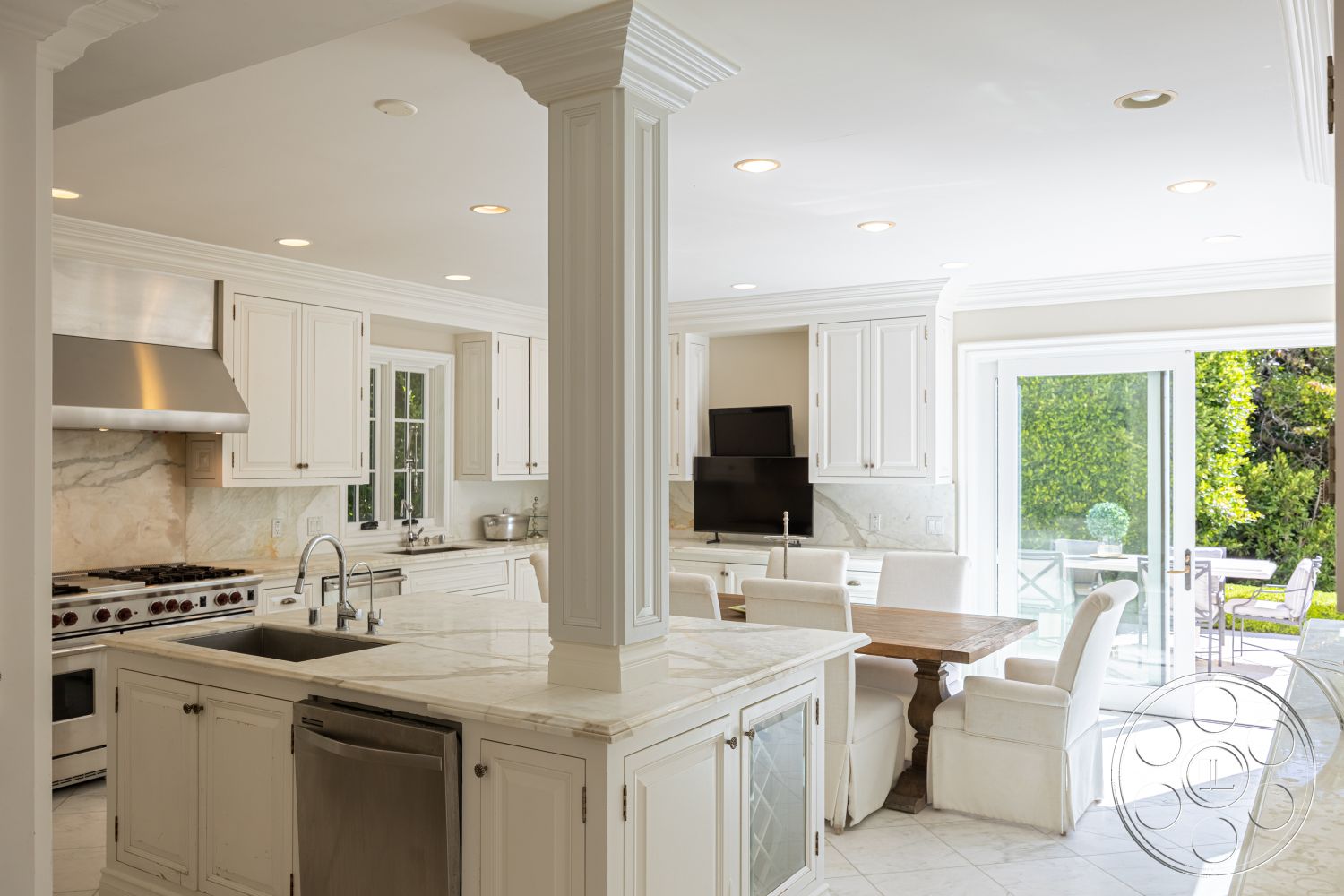 Americana 431 - subway tile backsplash, rectangular dining table, under-cabinet lighting, formal dining area, stainless steel kitchen appliances, marble kitchen countertops, interior kitchen design, open floor plan kitchen, brushed nickel faucet, decorative column details, white cabinetry with crown molding, glass doors leading to garden patio, tile flooring in kitchen, natural light filled kitchen, breakfast nook with wooden table, soft close cabinet drawers, exposed vent hood, coastal contemporary style, white upholstered dining chairs, built-in pantry