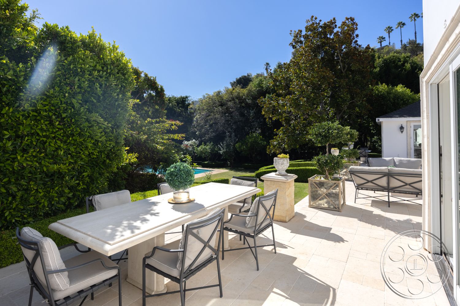 Americana 431 - potted plants, mature trees, urban oasis, low hedges, poolside area, exterior patio, metal dining chairs, landscaped garden setting, modern outdoor lighting fixtures, natural foliage backdrop, rectangular outdoor dining table, limestone patio flooring, plush outdoor cushions, stone garden planter, sunny residential backyard