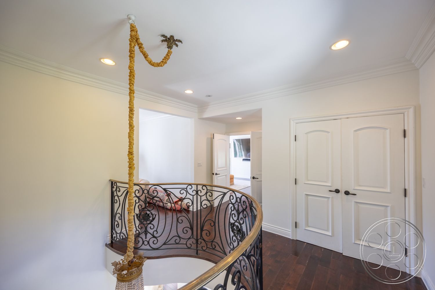 Americana 431 - natural light, hardwood flooring, recessed lighting, open concept design, transitional style, arched doorways, iron railing, decorative chandelier, curved staircase, elegant foyer, white painted walls, crown molding details, spacious landing area, double entry doors, plaster ceiling