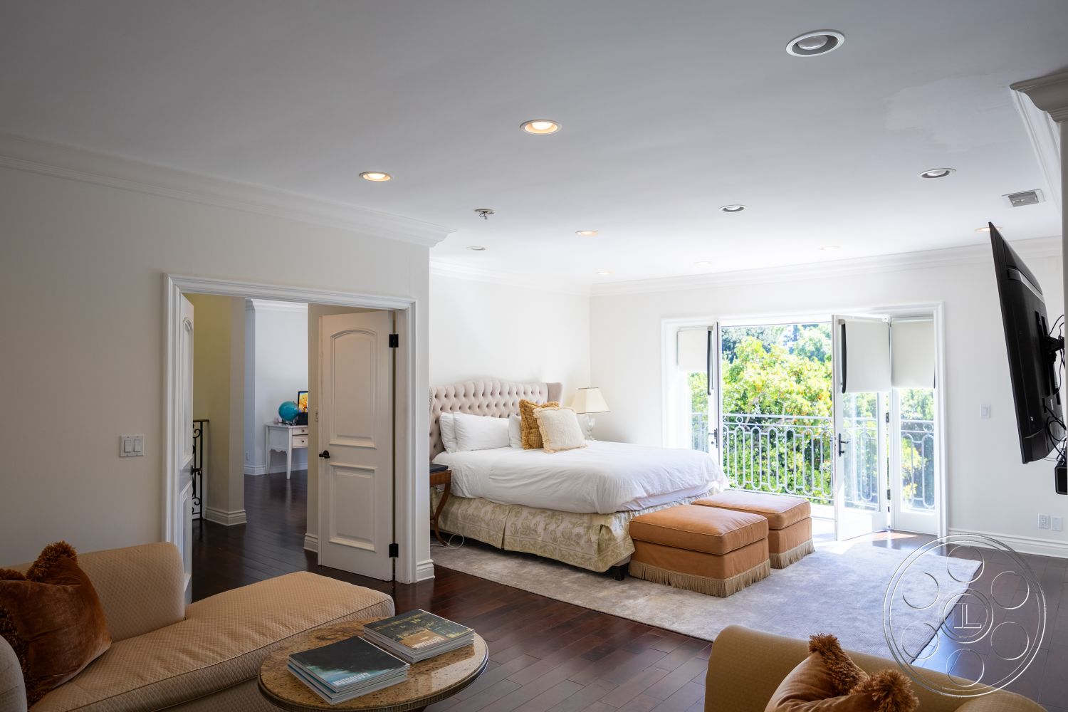 Americana 431 - textured rug, contemporary furniture, natural light from windows, elegant seating area, tufted headboard, designed for relaxation, hardwood bedroom floors, white painted walls, exposed crown molding details, outdoor balcony view, glass door opening to balcony, neutral-toned bedding, traditional interior, plush decorative cushions