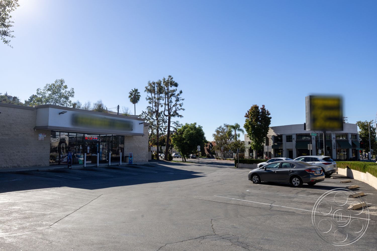 Shop 127 - exterior, modern architectural style, open outdoor space, city street view, asphalt parking lot, surrounding palm trees, flat roof design, urban commercial space, large glass storefront windows, concrete storefront walls, pedestrian sidewalk area, landscaped green borders, adjacent two-story building, accessible parking spaces