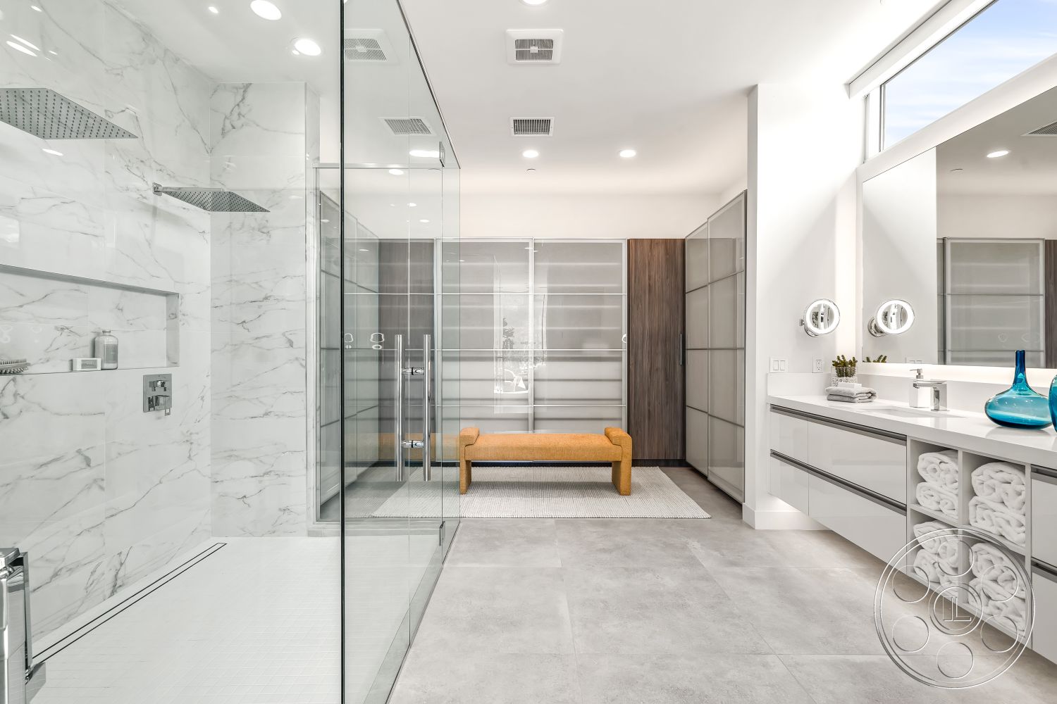 Palm Springs 109 - minimalist decor, neutral color palette, glass shower enclosure, modern light fixtures, natural light from large windows, luxury bathroom, sliding closet doors, open shower concept, contemporary bathroom design, interior bathroom space, marble shower walls, marble bathroom flooring, floating vanity with white cabinetry, textured gray tile accents, built-in shower niches, large format floor tiles