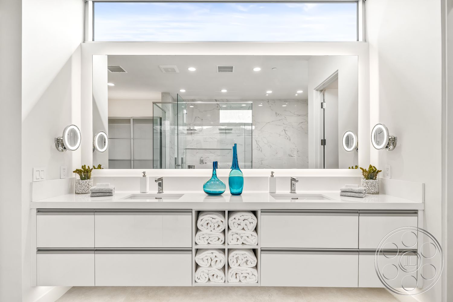 Palm Springs 109 - neutral color palette, minimalist design elements, white quartz countertop, open shower space, contemporary design style, decorative plant accents, frameless glass shower enclosure, tile bathroom flooring, LED mirror lighting, large window for natural light, sleek faucet fixtures, interior modern bathroom, floating vanity with storage, bathroom with natural light, simple decorative accents, white marble bathroom walls, double sink bathroom vanity, built-in shelving for towels