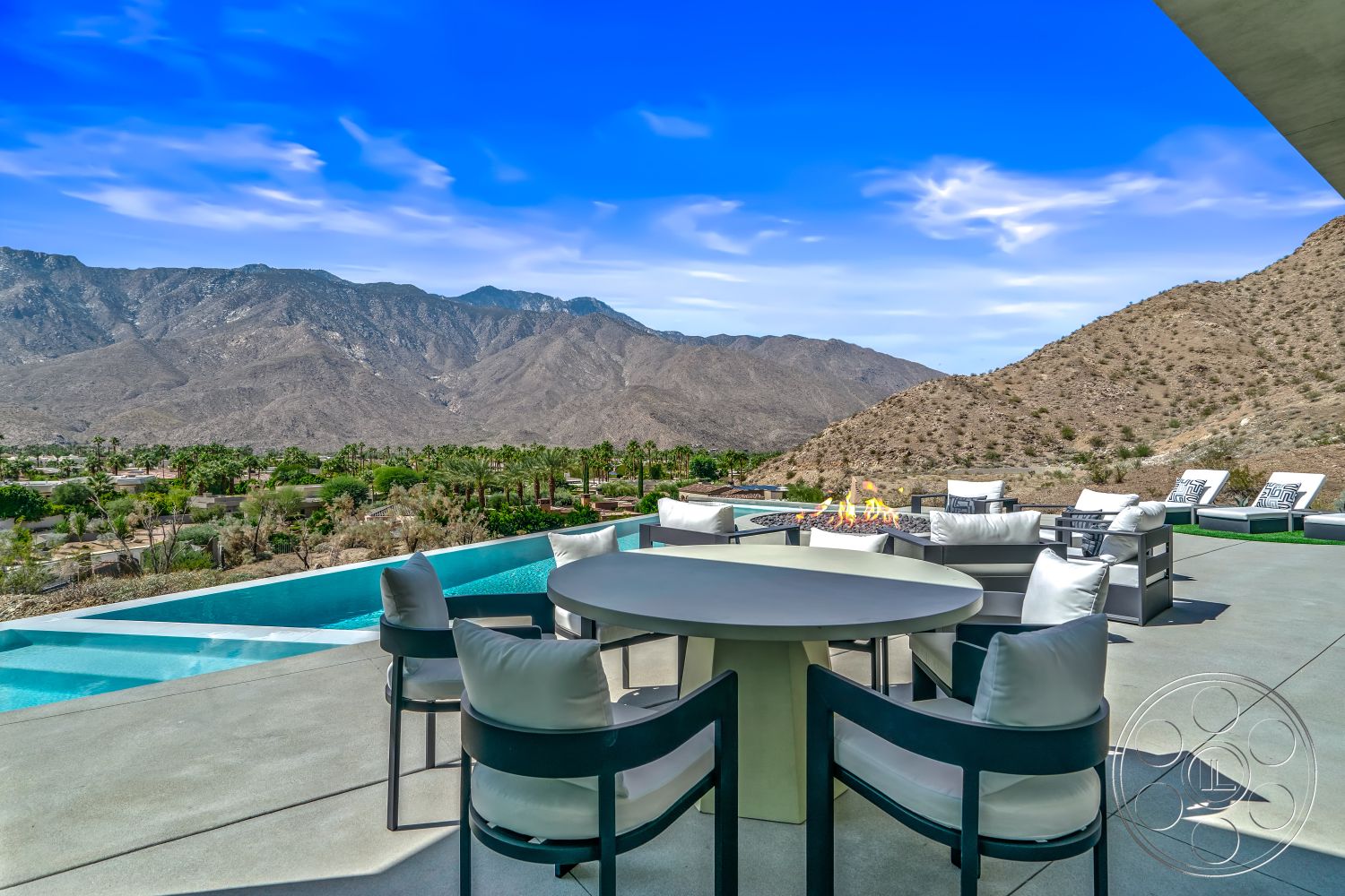 Palm Springs 109 - minimalist design elements, glass railing, modern outdoor furniture, contemporary architecture, landscape lighting, infinity pool, concrete terrace, outdoor fire pit, mountain view setting, exterior concrete patio flooring, palm tree garden, rectangular pool with waterfall edge, decorative pool water feature, sunny desert landscape, upper-level outdoor dining area, stone fire pit surround, open-air lounge space, natural stone steps down to pool