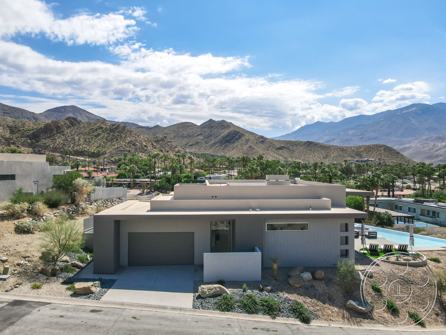 Palm Springs 109 - open floor plan, minimalist design elements, large glass windows, rectangular swimming pool, modern architectural style, flat roof design, exterior concrete driveway, exterior stucco walls, low-maintenance xeriscaping, concrete patio area, steel railing details, mountain view backdrop, desert climate adaptation, desert landscape setting, angular home shape, landscaped gravel garden, attached garage structure