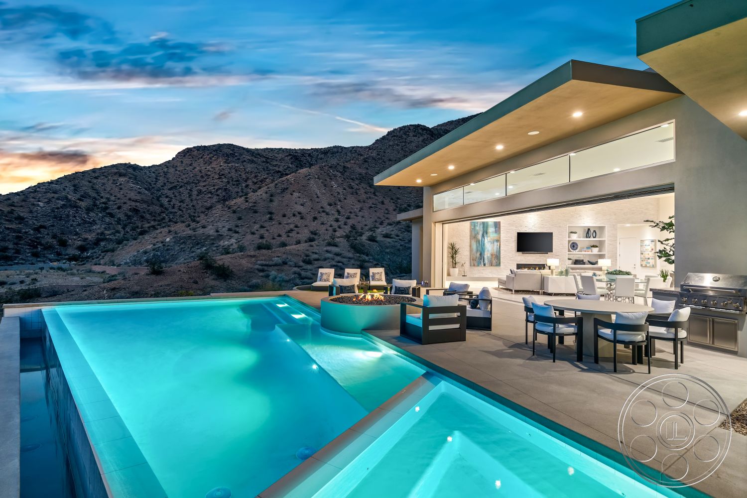 Palm Springs 109 - glass sliding doors, rectangular swimming pool, contemporary furnishings, sunset view, open concept living space, light wood ceiling, concrete patio flooring, white painted walls, stainless steel outdoor grill, infinity pool edge, smooth concrete pool border, exterior mountain setting, modern outdoor kitchen area, fire pit with seating area, expansive floor-to-ceiling windows, woven outdoor dining chairs, luxury desert home, landscaped desert surroundings, ceramic tile decking, minimalistic modern design