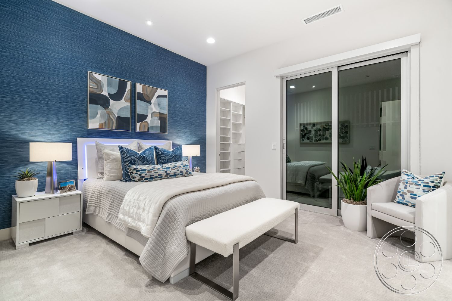 Palm Springs 109 - decorative pillows, serene atmosphere, artwork on wall, subtle lighting fixtures, indoor plant decor, glass sliding door, interior bedroom, minimalist nightstand, modern bed frame, soft carpet flooring, open closet space, clean lines design, neutral bedding, textured blue accent wall, contemporary bedside lamps, white armchair, modern bench, light-colored decorative accents, shelves for storage