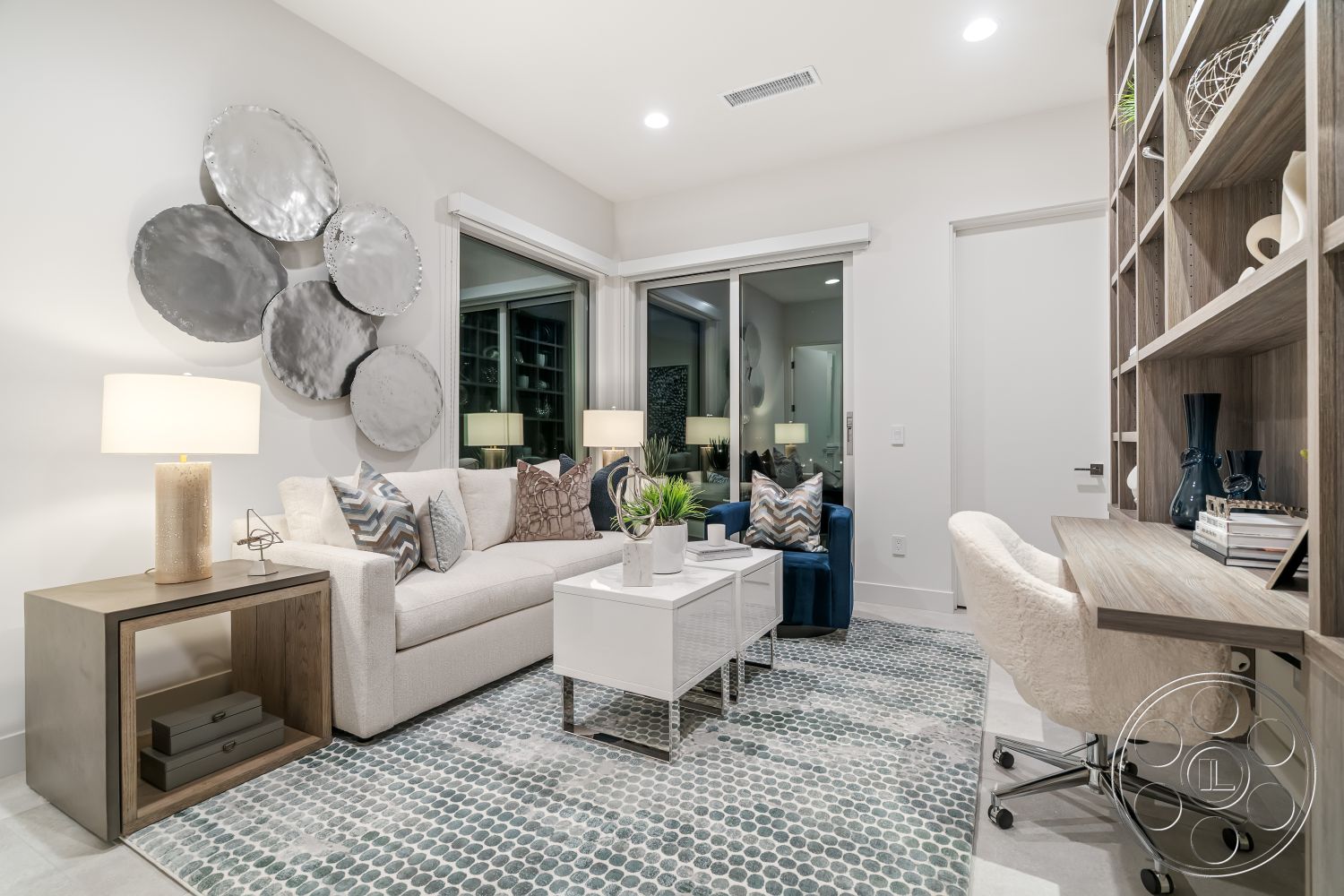 Palm Springs 109 - light hardwood flooring, cozy reading nook, minimalist decor elements, white painted walls, glass sliding door for natural light, interior modern living room, integrated shelving unit, contemporary neutral color palette, metal wall art installation, textured area rug with geometric pattern, modern white coffee table, dark wood side table, soft fabric sofa with decorative pillows, elegant table lamp with white shade, open bookshelf for storage, stylish desk with ergonomic chair, large windows for city skyline view