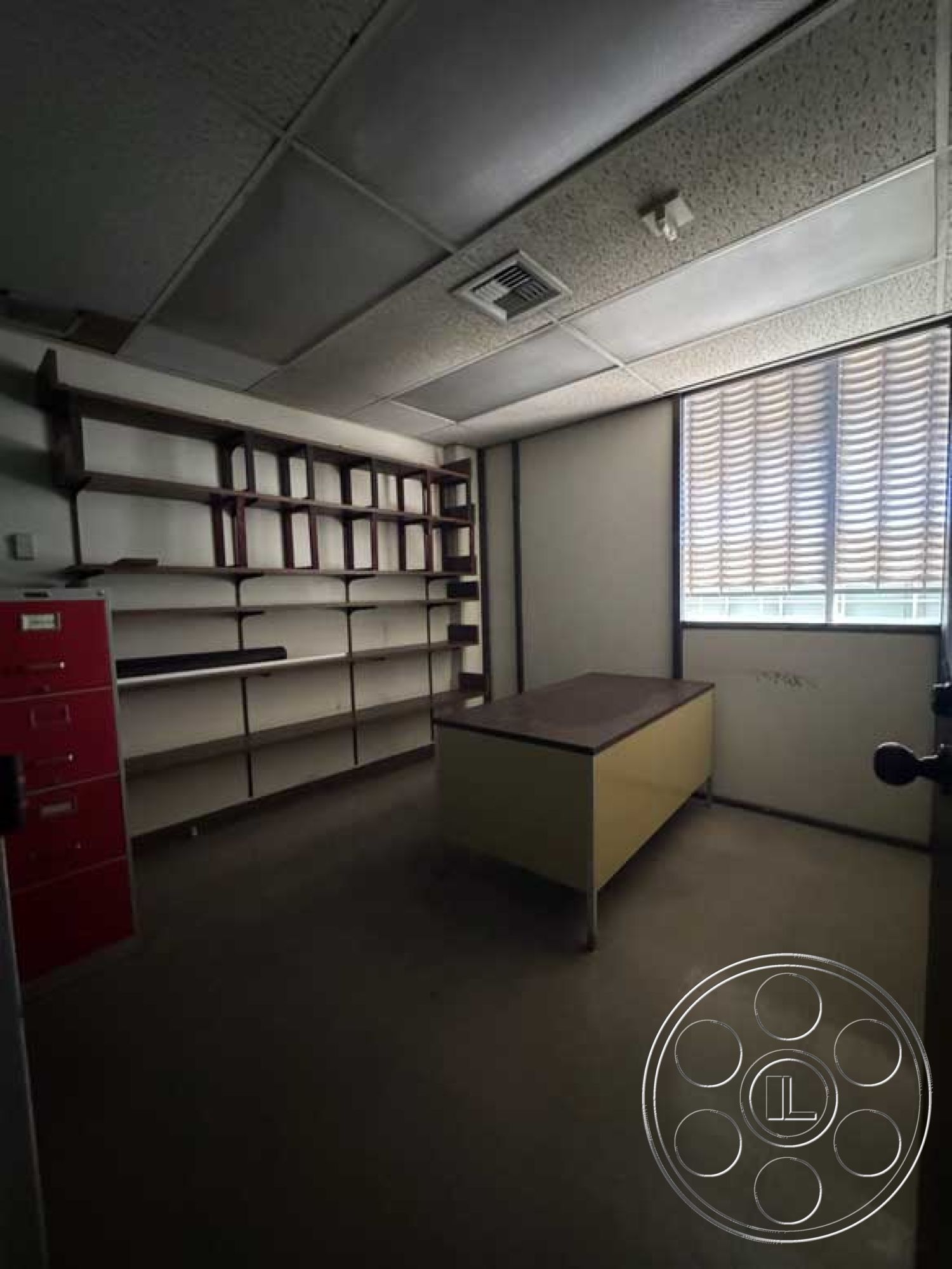 School 3 - minimalist design, neutral wall color, vinyl flooring, interior office space, textured acoustic ceiling tiles, workspace with natural light, laminate countertop desk, open shelving system, large vertical window with blinds, red filing cabinet