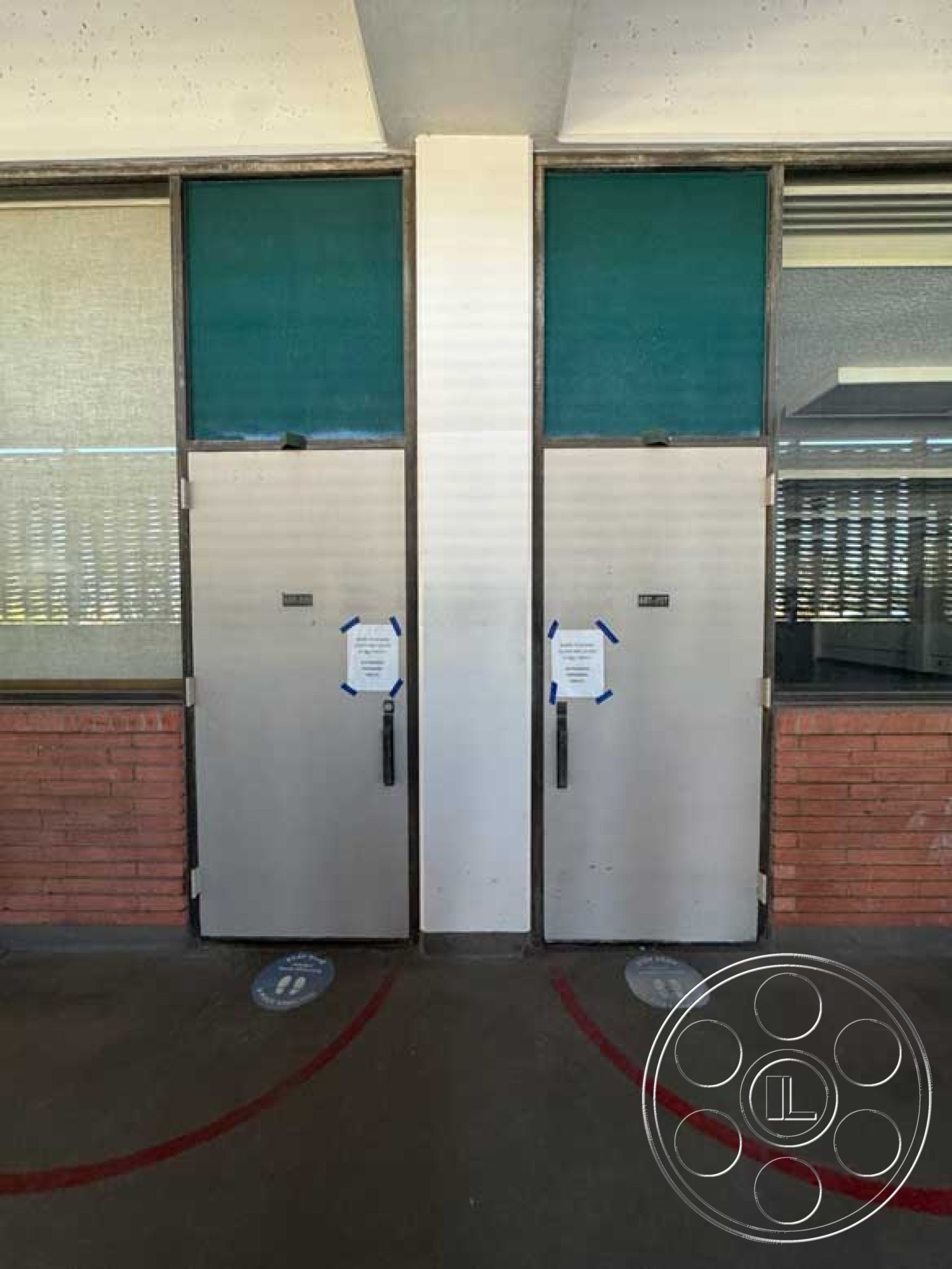 School 3 - concrete floor, glass wall panels, industrial architectural style, exterior brick wall, commercial building façade, exterior metal doors, vertical stripes door design, bronze metal hardware on doors, textured door surface, interior observation area, symmetrical entrance design, clear signage details