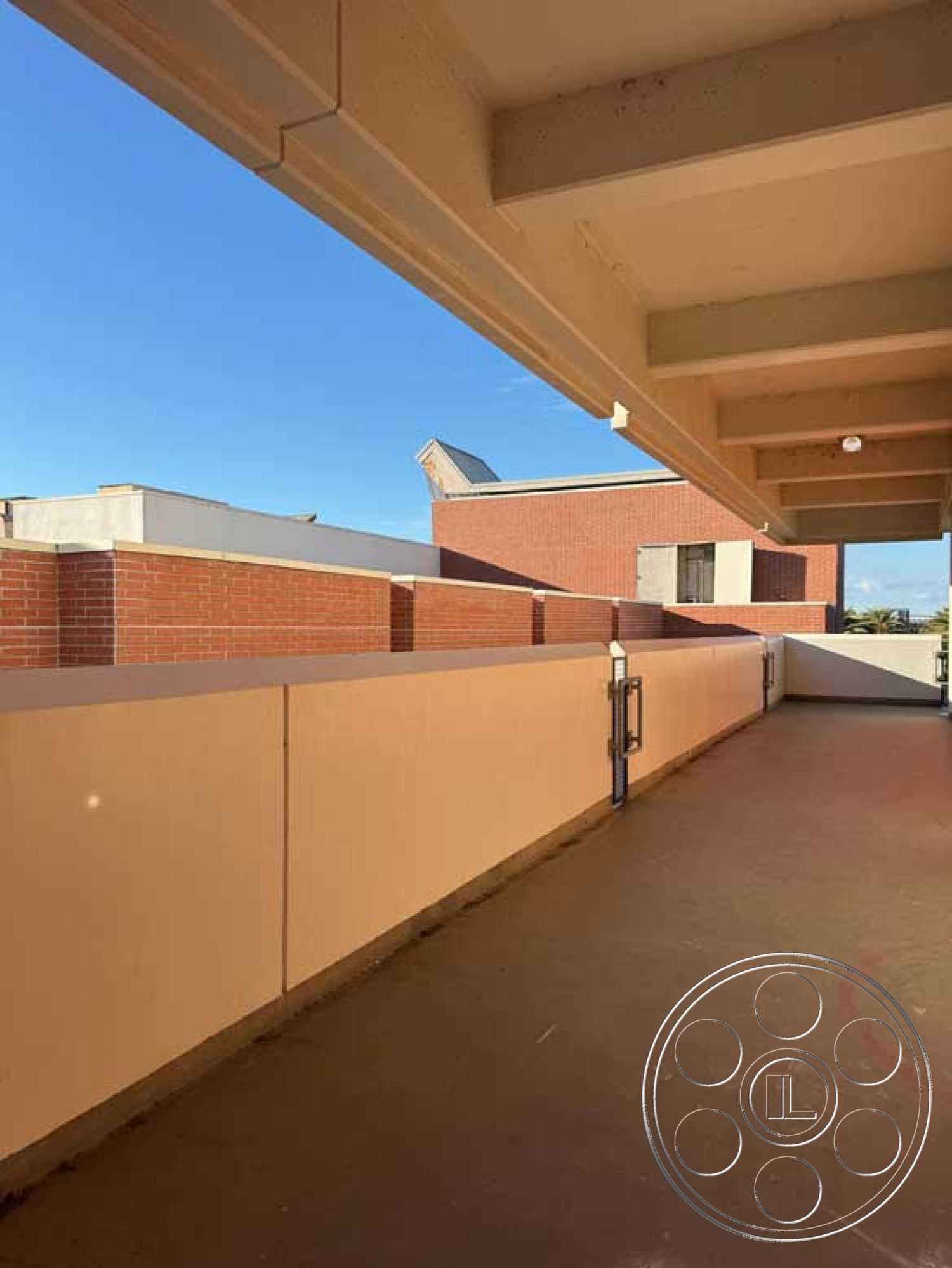 School 3 - exterior, urban setting, steel railing, modern architectural style, red brick wall, clear blue sky view, flat roof profile, smooth stucco wall treatment, concrete balcony floor, overhang roof structure