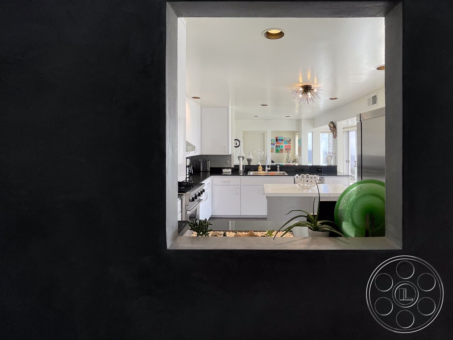 Modern 56 - neutral color palette, minimalist design, stainless steel appliances, open concept layout, modern decor accents, black granite countertop, recessed lighting fixtures, interior kitchen, large picture window, kitchen island with seating, black textured plaster walls, modern white cabinetry, contemporary pendant light, decorative plant on countertop, glass decorative objects