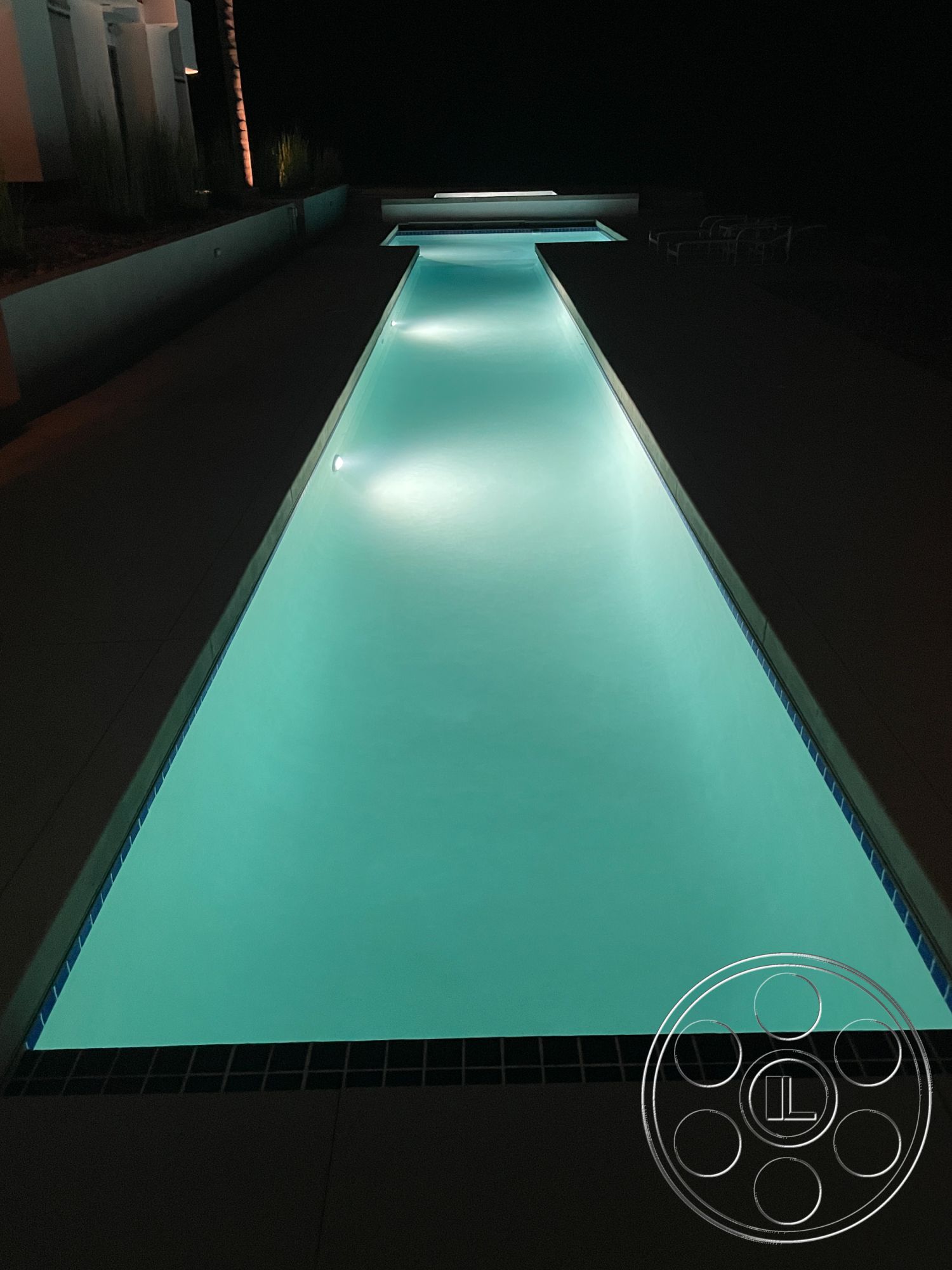 Modern 56 - nighttime ambiance, modern landscape design, concrete pool deck, rectangular pool, concrete patio flooring, clean lines architecture, exterior pool area, exterior lighting fixtures, minimalist outdoor setting, blue tile pool border, surrounding hardscape features
