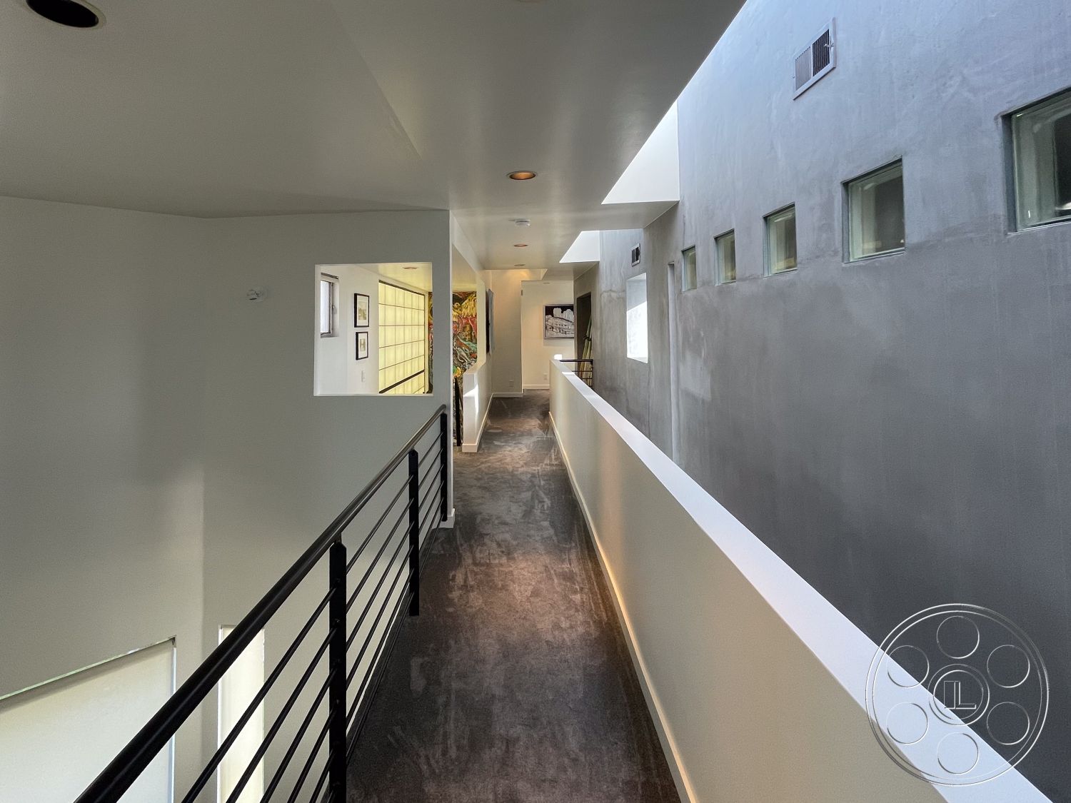 Modern 56 - neutral color palette, soft natural lighting, flush ceiling lights, contemporary design aesthetic, open floor plan layout, large rectangular windows, exposed concrete accent wall, clean lines and geometric shapes, interior hallway with concrete wall finish, striped carpet flooring in hallway, modern metal stair railings, minimalist wall sconces, architectural glass blocks, plastered wall treatments