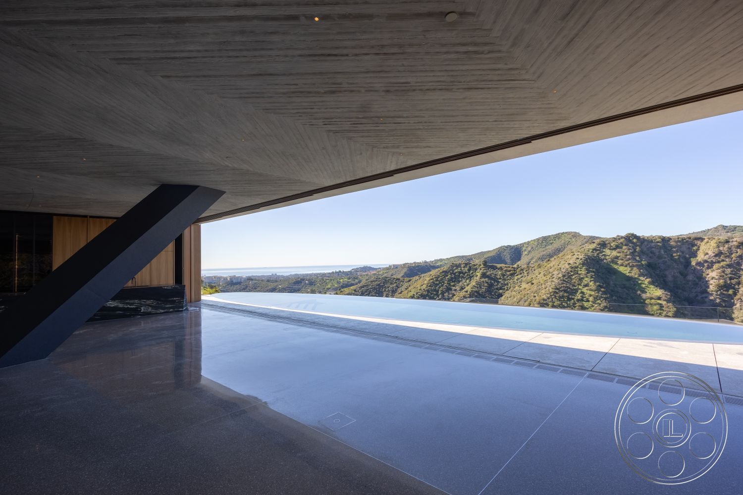 Modern 516 - open floor plan, polished concrete flooring, floor-to-ceiling windows, exposed concrete ceiling, infinity edge pool, sloped landscape, large sliding glass doors, mountain view setting, interior living space, minimalist architectural style, contemporary design features, wooden accent walls, glass wall installation, modern outdoor terrace, cantilevered structural elements