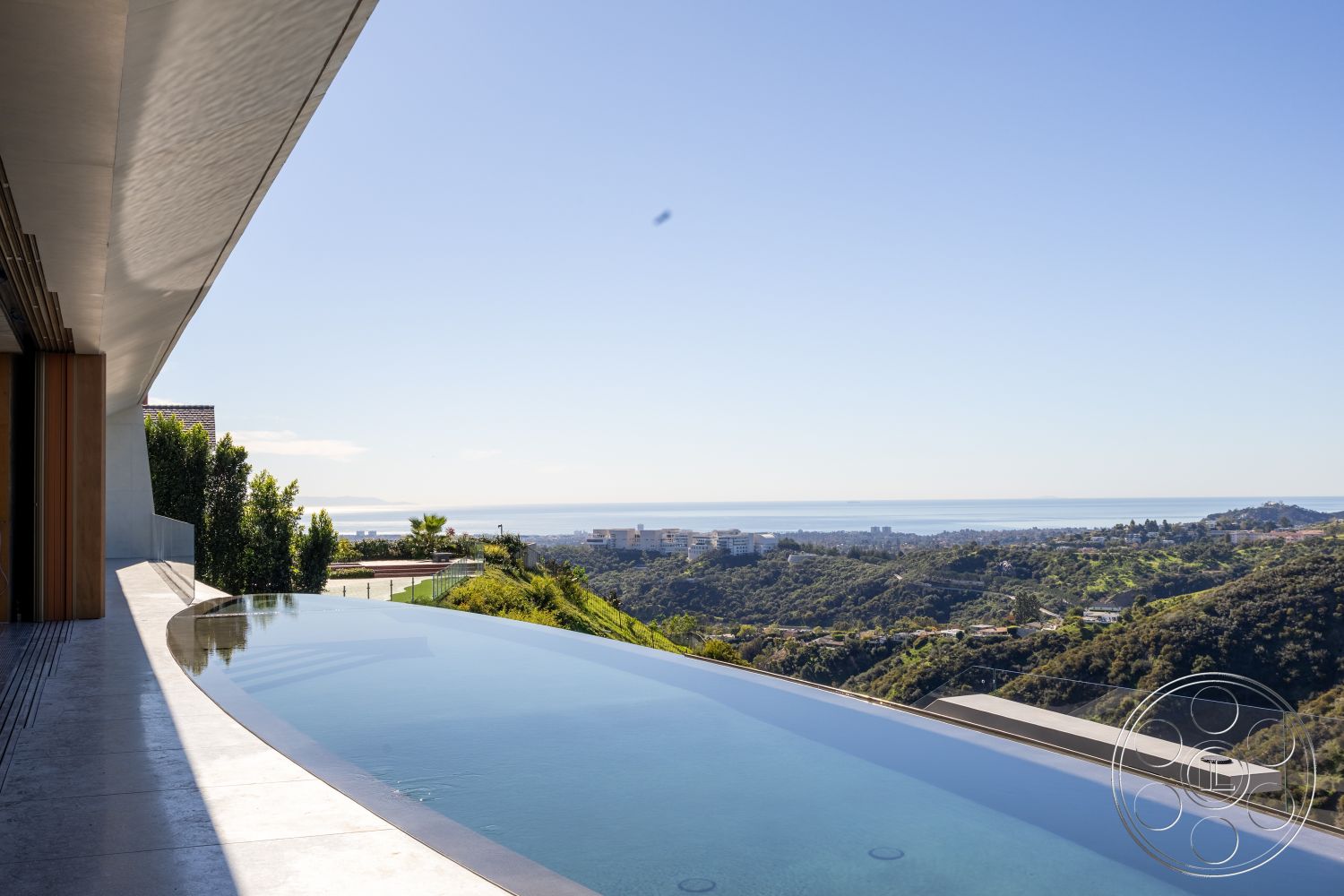 Modern 516 - landscaped garden, open floor plan, glass railing, floor-to-ceiling windows, outdoor living space, infinity pool, wooden sliding doors, flat roof design, mountain view setting, concrete pool border, minimalist architectural style, concrete patio floor, suburban hillside location, natural light infused interior, exterior walls with neutral finishes, concrete hardscape