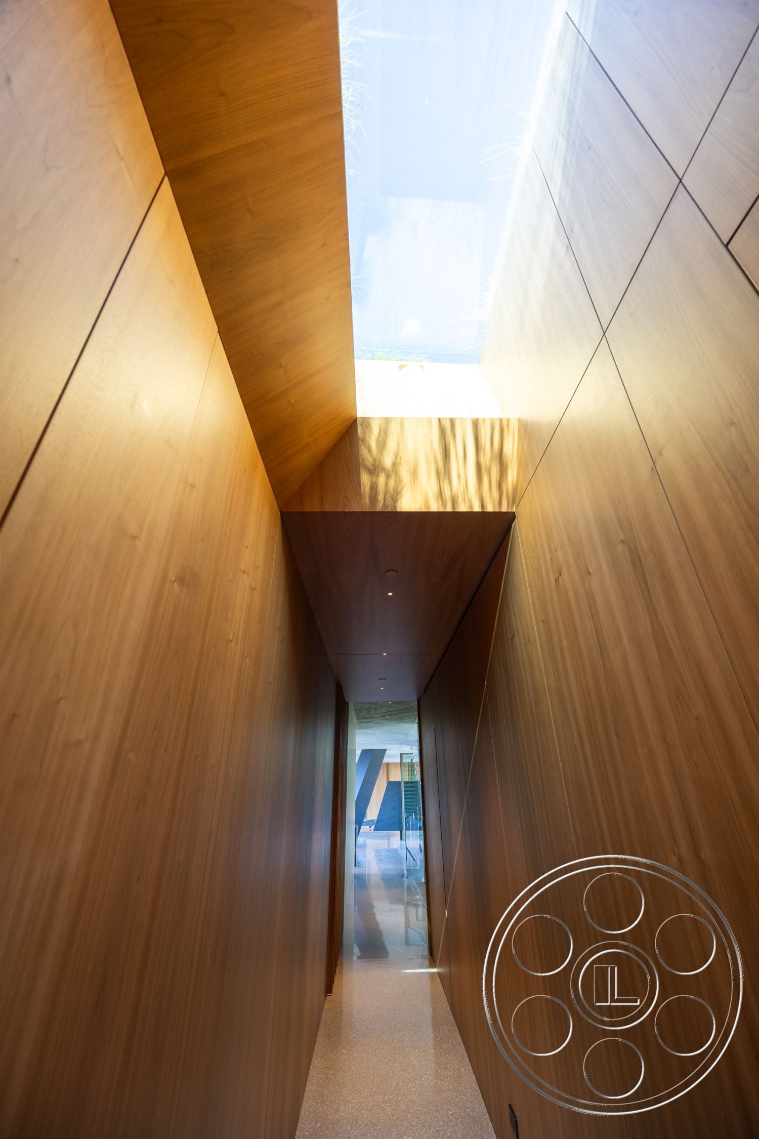 Modern 516 - terrazzo flooring, open concept layout, natural light interior, ambient recessed lighting, minimalist architectural details, modern hallway design, interior wooden wall paneling, skylight feature, sloped ceiling design, glossy finish wood accents, abstract geometric forms