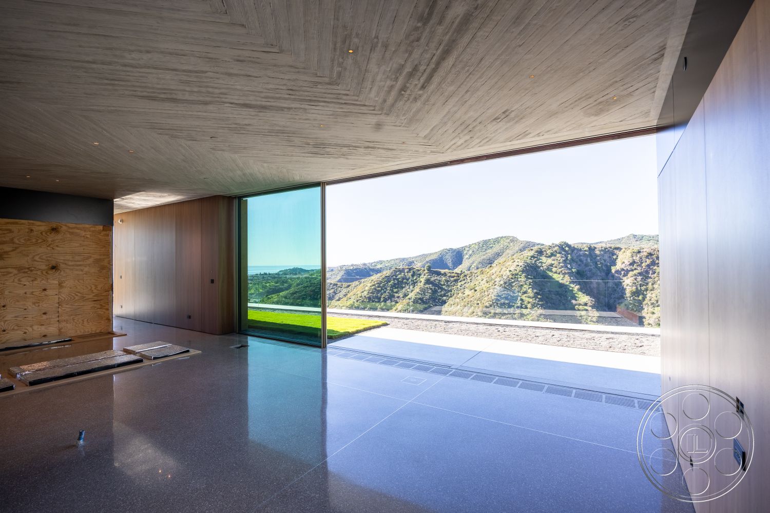 Modern 516 - interior subtle color palette, interior open floor plan, interior recessed lighting fixtures, interior polished concrete flooring, modern architectural design, exterior mountain view, interior multifunctional space, interior concrete ceiling with textured finish, exterior floor-to-ceiling glass windows, interior wood panel wall treatment, interior plywood accent wall, exterior outdoor patio area, interior minimalist layout, exterior natural landscape integration, exterior sleek architectural lines