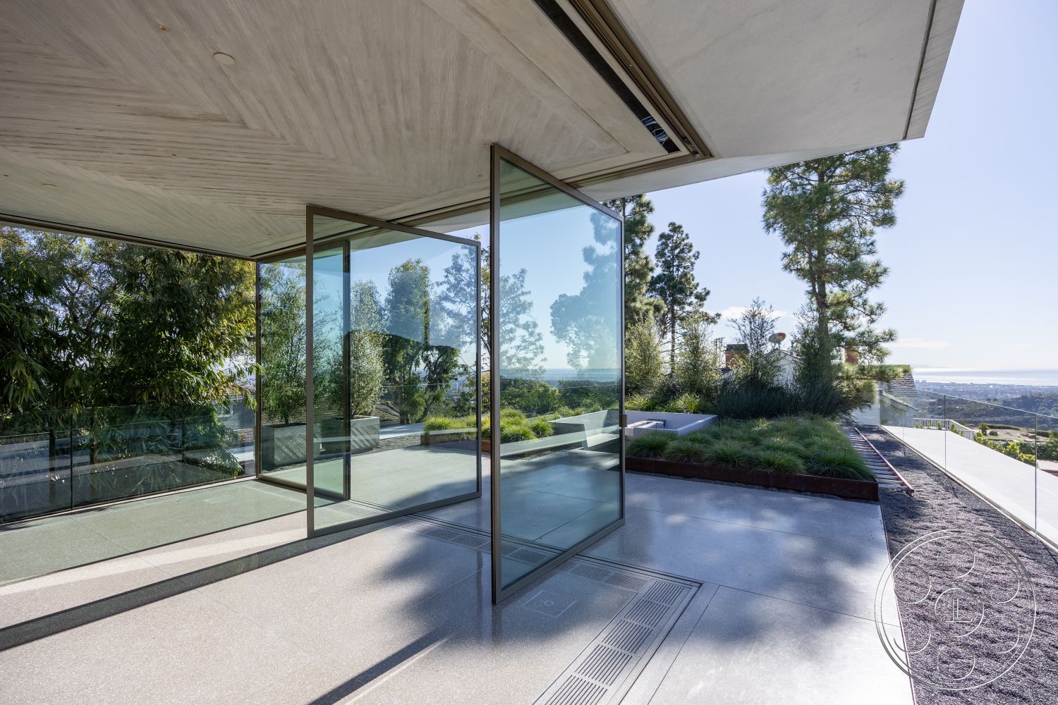 Modern 516 - open-concept living space, large floor-to-ceiling windows, contemporary outdoor living space, modern minimalist architecture, interior glass sliding doors, exterior polished concrete flooring, natural light-filled interior, sloped landscape design, concrete ceiling with exposed finish, landscape garden area with greenery, metal railing with glass partitions, city skyline view from patio, structured outdoor seating area, smooth concrete wall treatment, elevated outdoor terrace, modern angular roofline, integrated drainage system, luxurious relaxation zone