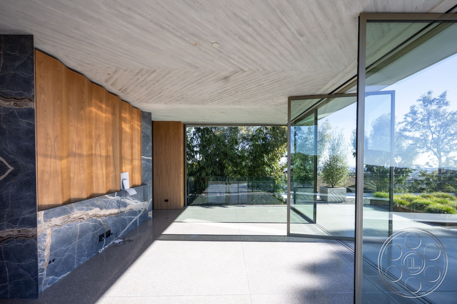 Modern 516 - interior: recessed lighting fixtures, interior: floor-to-ceiling glass windows, interior: polished concrete flooring, interior: walnut wall paneling, interior: stone accent wall with veining, interior: minimalistic modern design, exterior: landscaped garden space, interior: high ceilings with textured finish, interior: seamless transition to outdoor patio, interior: contemporary open plan living space, interior: bias-cut natural stone countertop, exterior: panoramic views of greenery, interior: sleek glass sliding doors