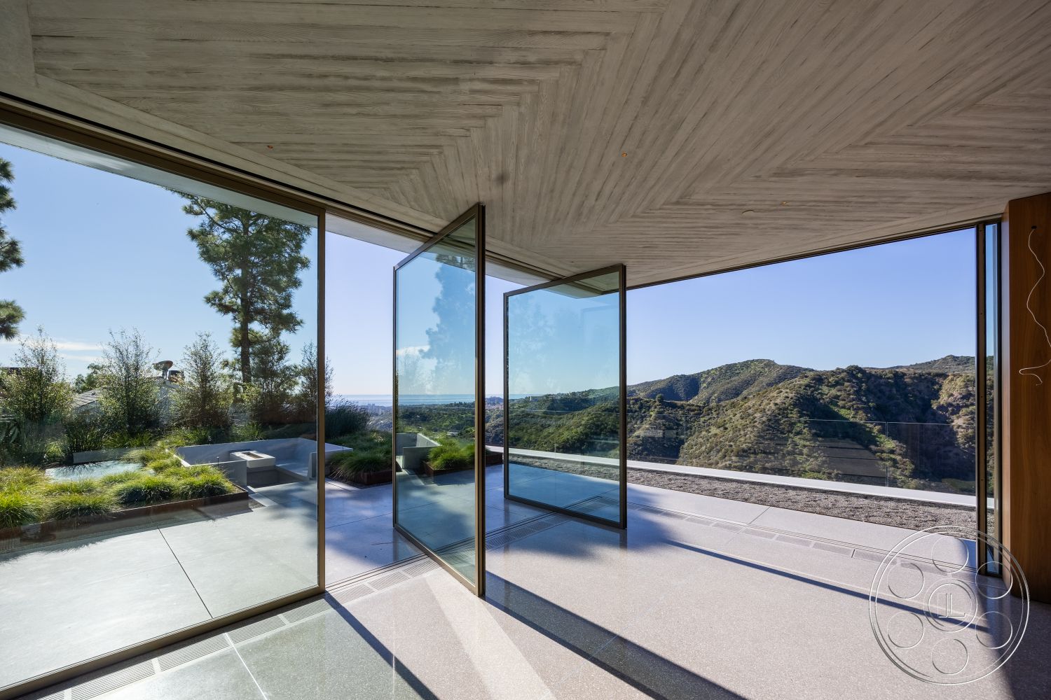 Modern 516 - polished concrete flooring, modern architectural style, horizontal wood paneling, exposed concrete ceiling, integrated indoor-outdoor flow, minimalist outdoor space, mountain view setting, natural light-filled space, concrete patio floor, floor-to-ceiling glass walls, landscaped garden with native plants, open concept interior design, sleek glass courtyard, steel and glass structural elements, designed for mountain climate