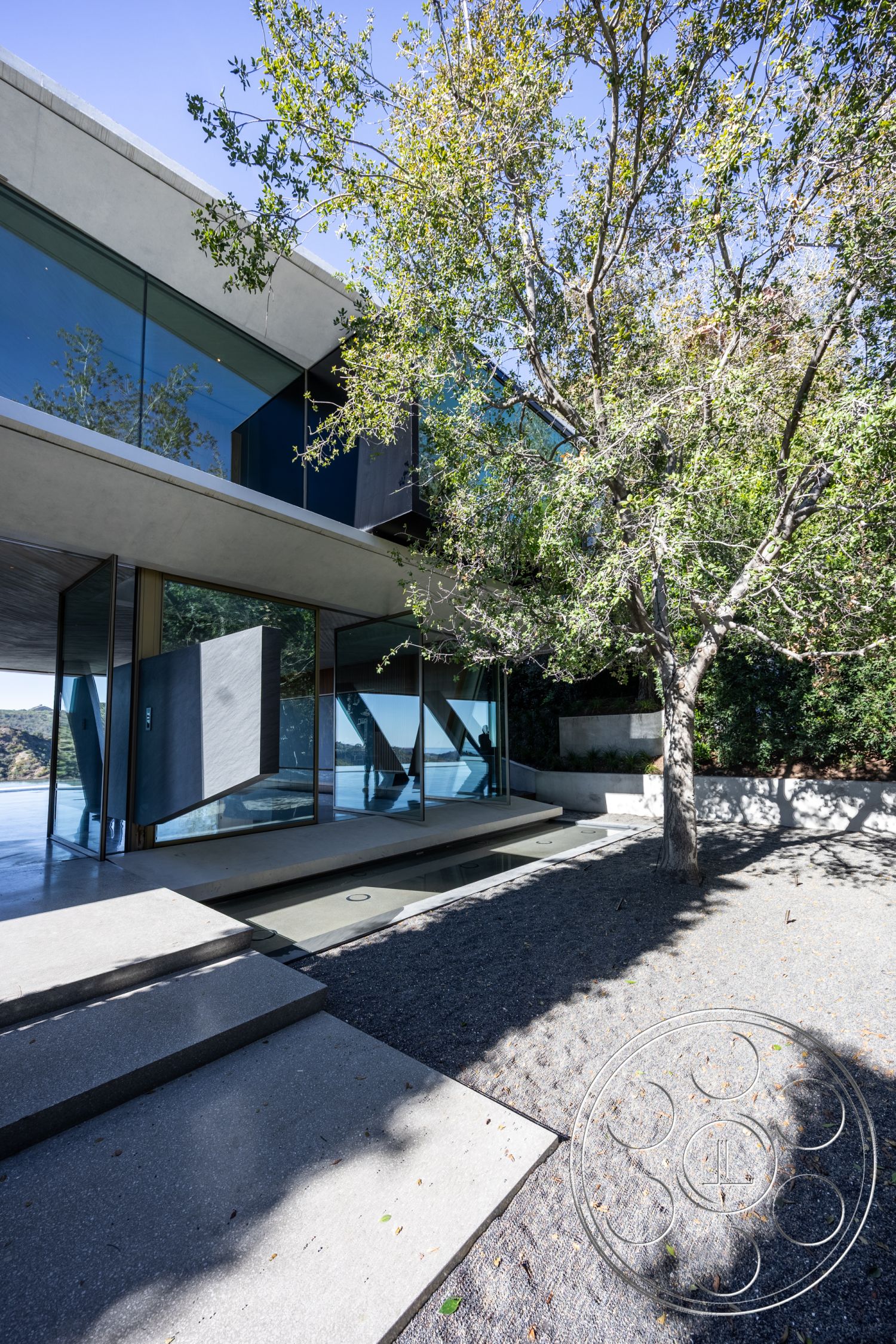 Modern 516 - exterior, sliding glass doors, concrete steps, modern architectural style, concrete walkway, tree shade, gravel ground cover, overhanging eaves, landscaped garden area, floor-to-ceiling glass windows, natural light emphasis, contemporary exterior design, minimalist facade, steel structural supports, cantilevered roof