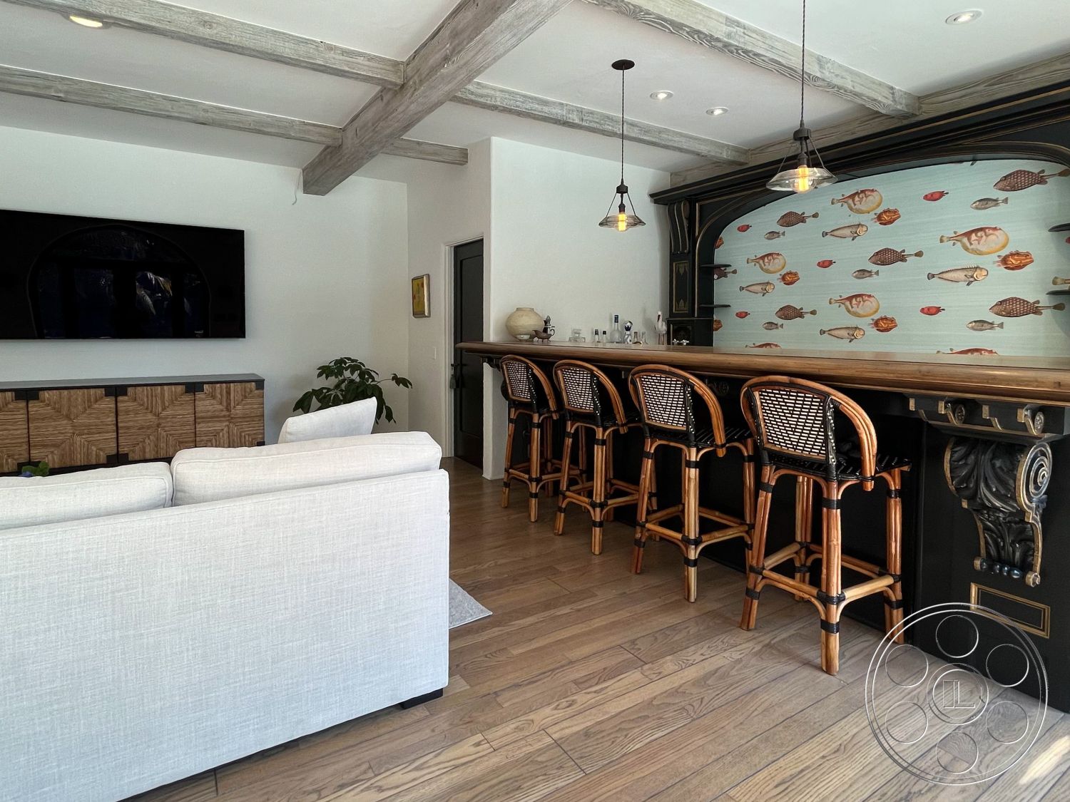 Medit 166 - interior neutral color palette, interior recessed lighting, interior hardwood living room floors, interior cozy seating area, interior wood beam ceiling, interior open concept design, interior bar area with rattan bar stools, interior textured wall with fish mural, interior flat-screen TV wall, interior woven storage cabinet, interior pendant lighting above bar