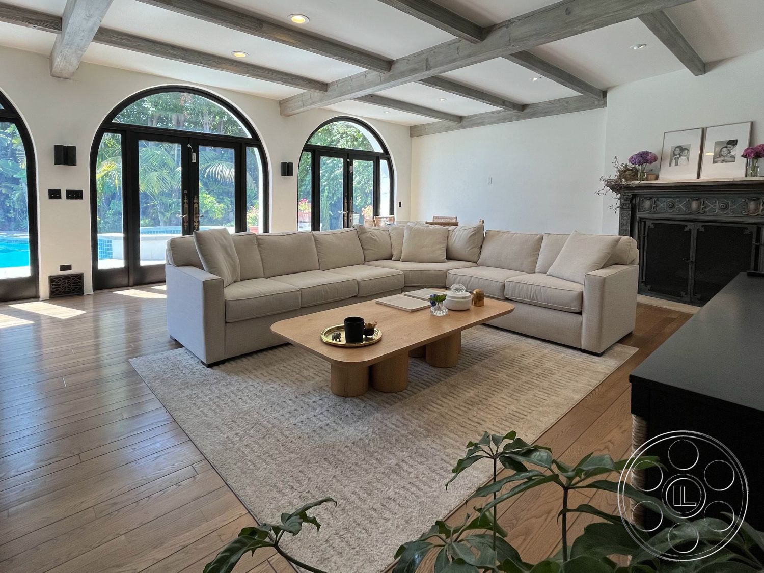 Medit 166 - large glass sliding doors, indoor-outdoor flow, floor-to-ceiling windows, arched doorways, minimalist coffee table, exposed wood ceiling beams, hardwood living room floors, neutral color palette interior, open concept living area, modern sectional sofa, structured lighting fixtures, natural light-filled interior, contemporary area rug, beachfront patio, black fireplace mantle, indoor houseplants