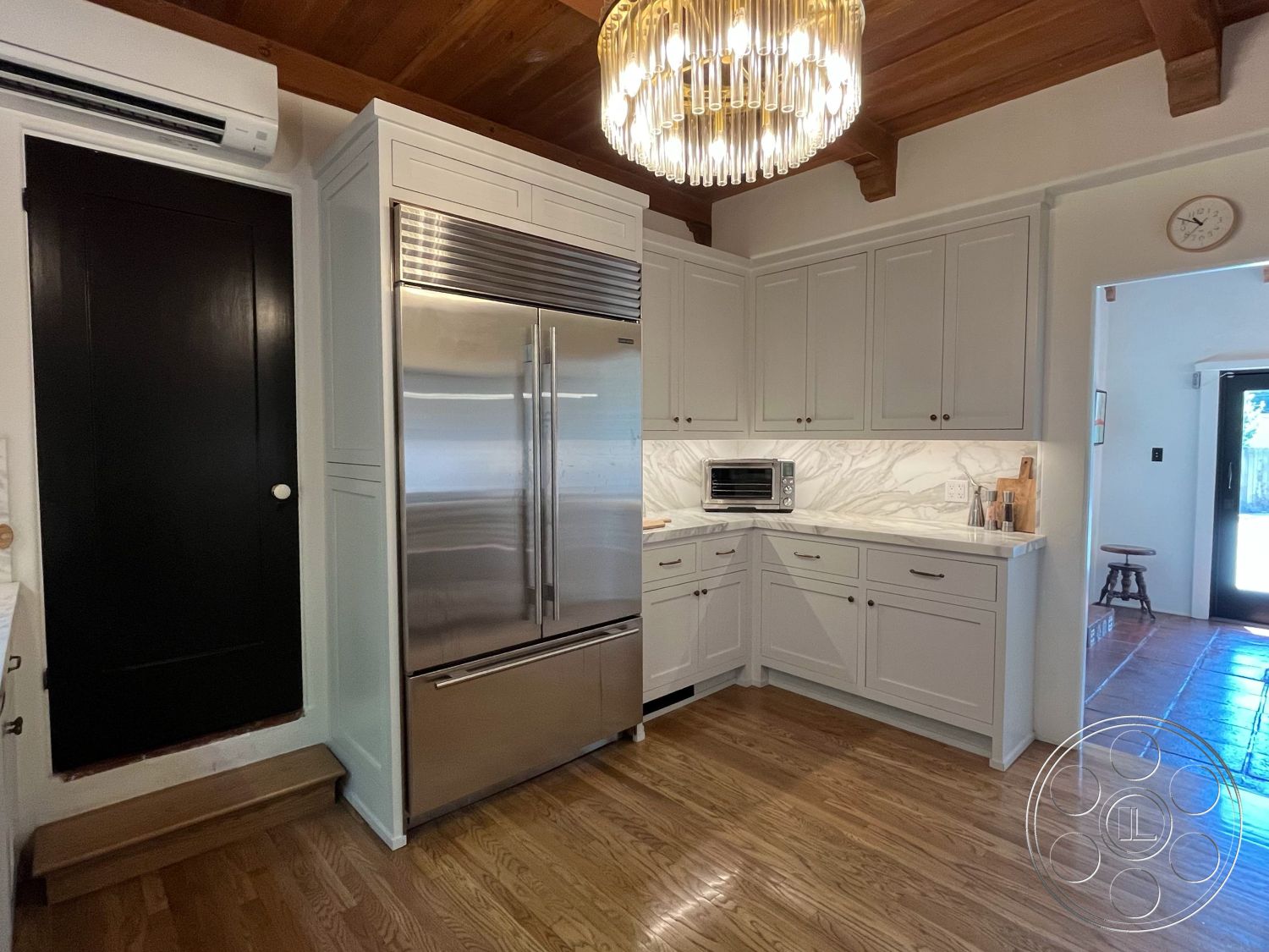 Medit 166 - natural light, hardwood flooring, white cabinetry, textured wall surface, modern chandelier, stainless steel refrigerator, tile backsplash, marble kitchen countertops, open kitchen layout, interior kitchen, contemporary kitchen style, wood beam ceiling, built-in kitchen appliances, black interior door, corner kitchen design