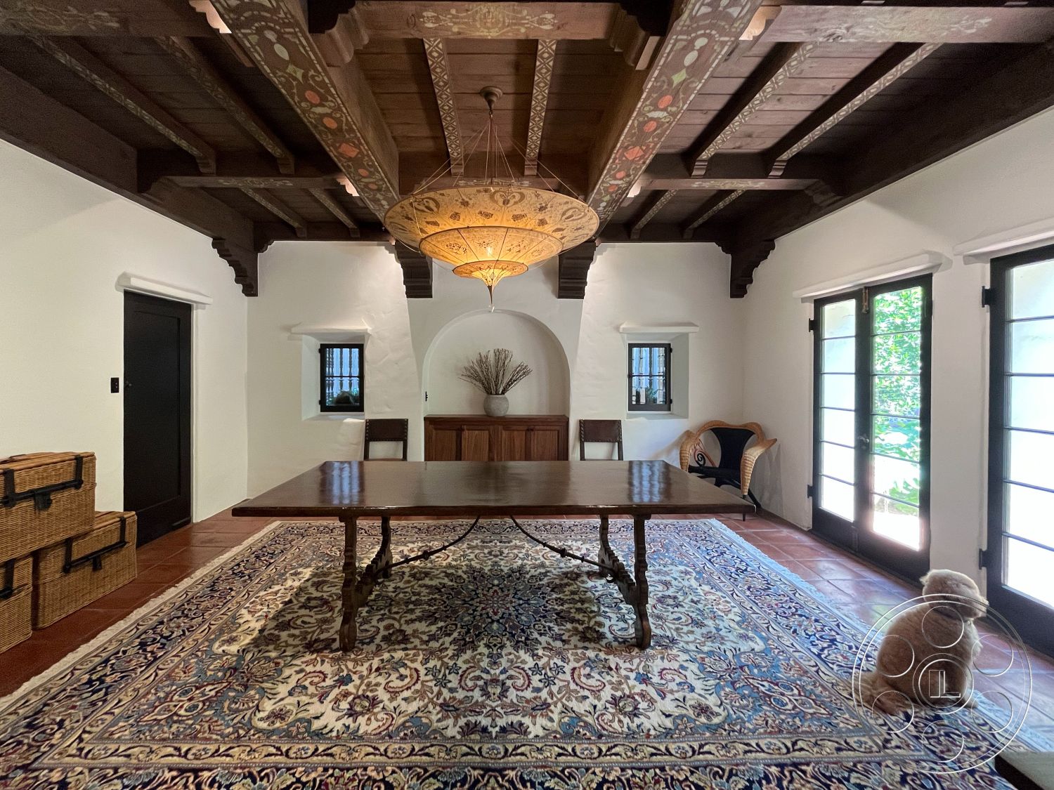 Medit 166 - arched doorways, textured plaster walls, terracotta tile flooring, woven rattan chair, exposed wood ceiling beams, handwoven area rug, antique wooden dining table, ornate pendant chandelier, traditional wooden cabinetry, natural light from French doors, decorative wall niches, elegant plant decor, rustic style home, Mediterranean architectural details