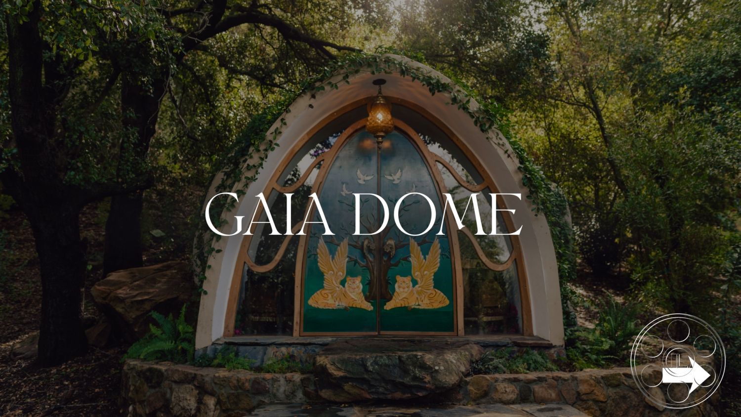 Topanga Retreat - arched entrance, hillside location, organic shapes in architecture, forest setting, natural stone foundation, exterior dome structure, wooden door with ornate carvings, greenery surrounding structure, rustic path with stepping stones, decorative light fixture at entrance, wood accent details, natural landscaping with ferns, eco-friendly design principles, custom artistic details, integrated into natural environment