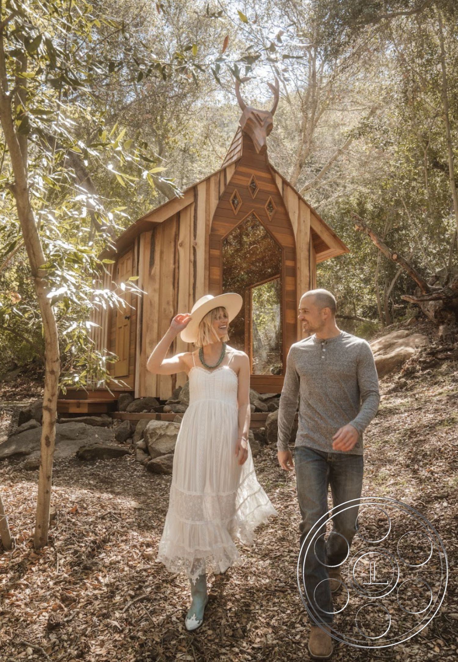 Topanga Retreat - exposed wooden beams, integrated nature elements, open-air environment, outdoor retreat, natural stone pathway, environmentally conscious design, gabled roof design, nature-inspired aesthetic, forest setting, diamond-shaped window accents, wooden siding exterior, rustic cabin architecture, landscape with oak trees, wooden steps leading to entrance