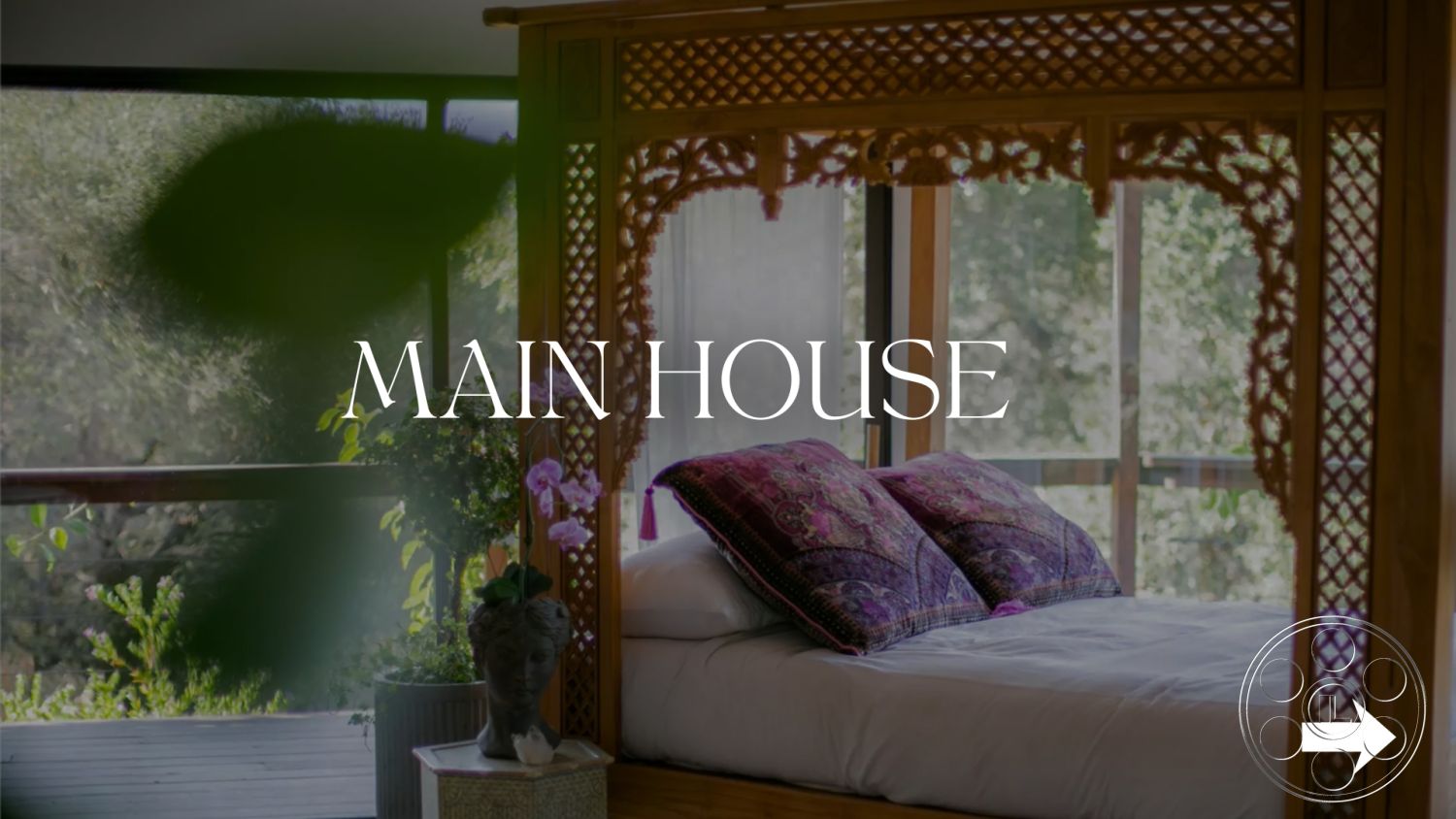 Topanga Retreat - floor-to-ceiling windows, open-concept living space, integrated indoor-outdoor flow, natural light interior, soft textile bedding, indoor plant accents, neutral color palette walls, plush decorative pillows, modern rustic interior, contemporary bedside table, minimalist bedroom design, wooden carvings on bed frame, modern wooden ceiling, nature view from windows, artisan decorative accents, airy bedroom atmosphere, serene bedroom environment