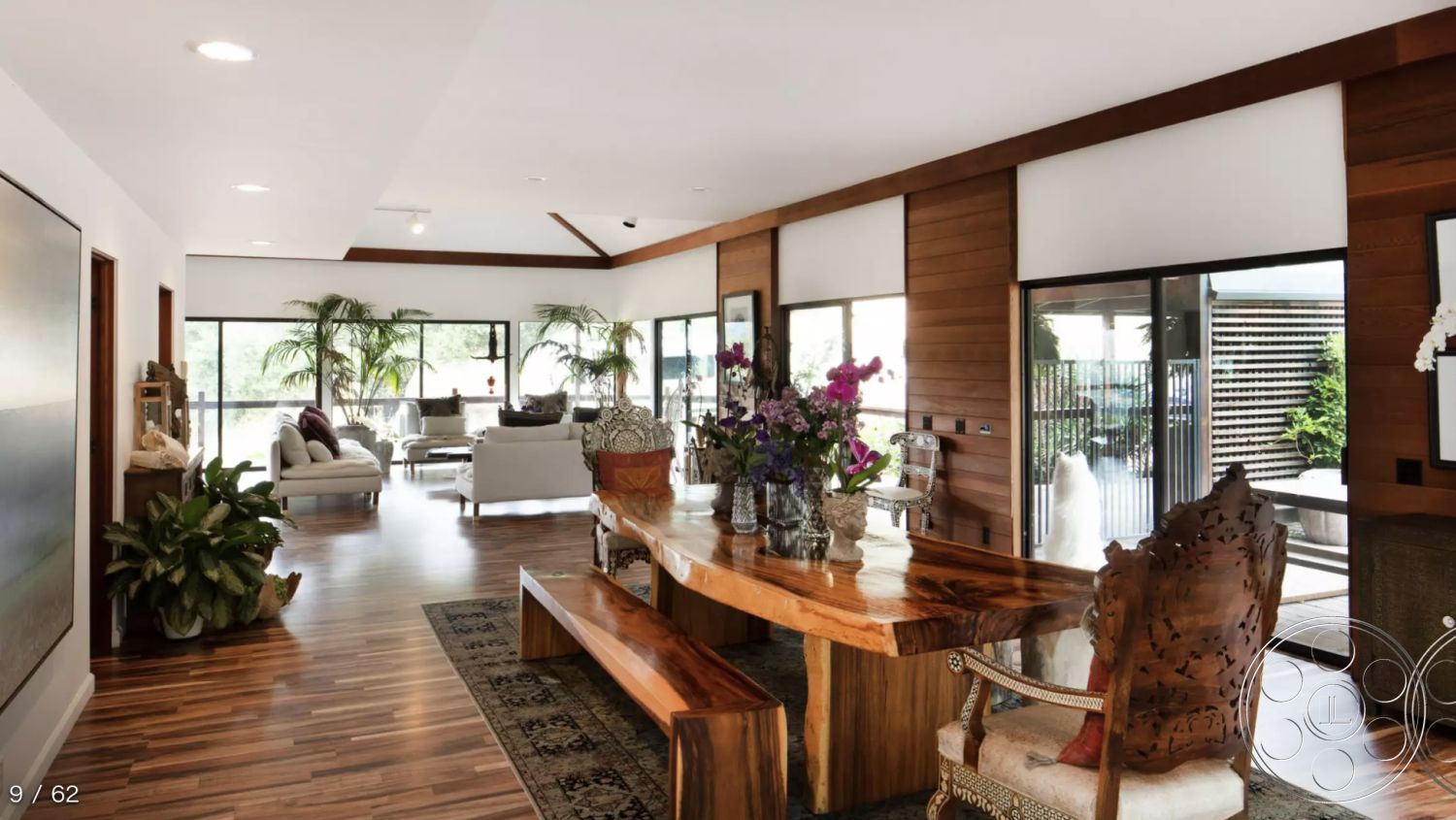 Topanga Retreat - white walls, large glass sliding doors, modern lighting fixtures, open concept layout, wood dining table, floor-to-ceiling windows, elegant floral arrangements, exposed wood ceiling beams, interior dining area, hardwood living room floors, natural light-filled space, minimalist interior design, textured wood paneling, potted indoor plants, contemporary armchairs, organic-shaped dining bench